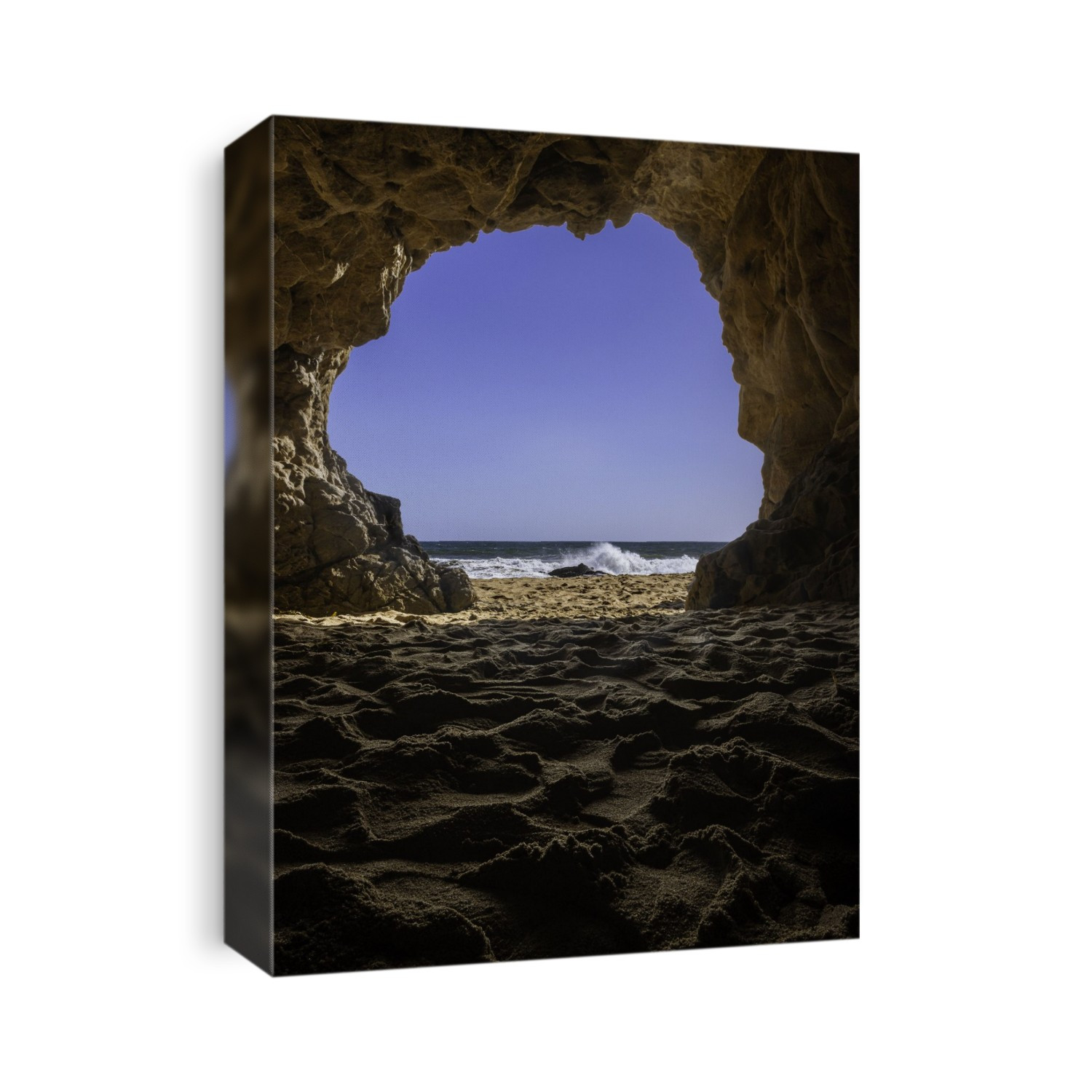The Pacific Ocean crashing over rocks from a cave in Malibu, California