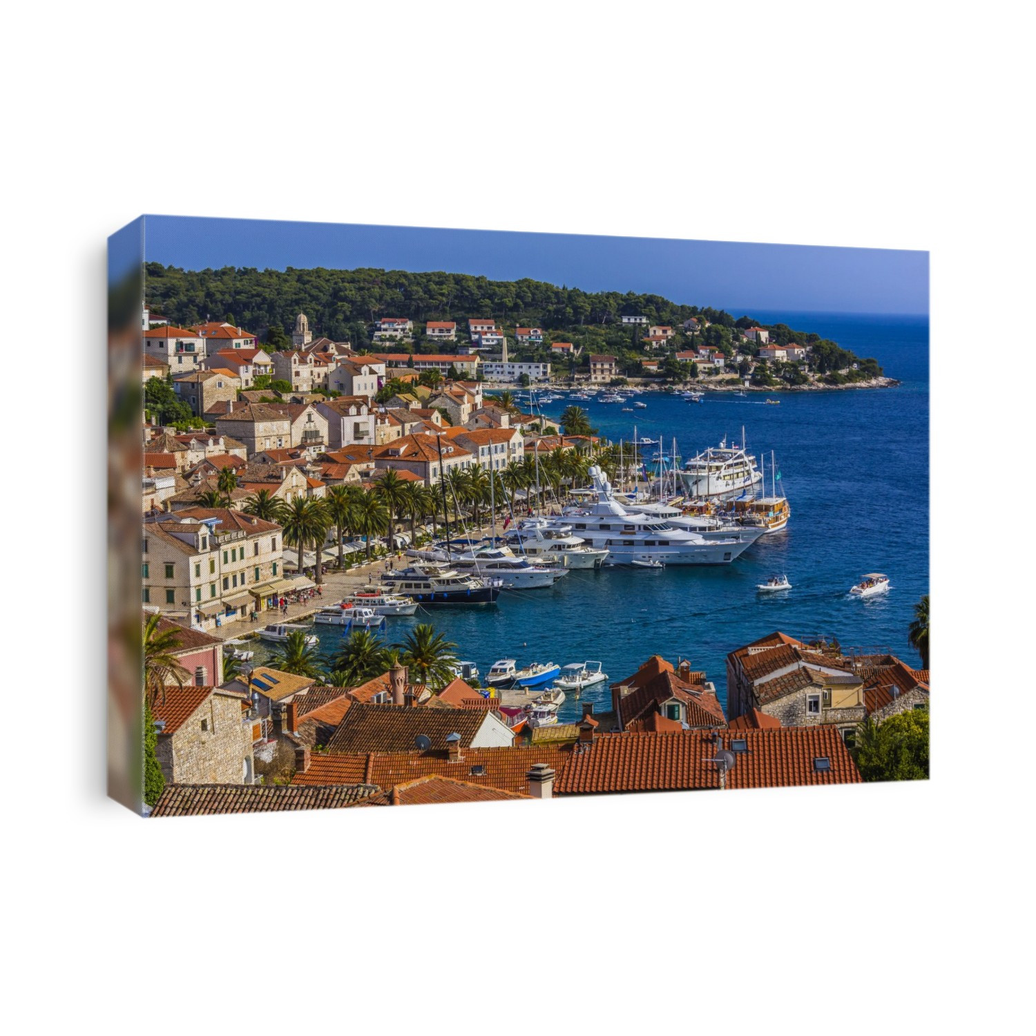 Overview of clay tile rooftops and luxury yachts docked in marina at the Old Town of Hvar on Hvar Island, Croatia