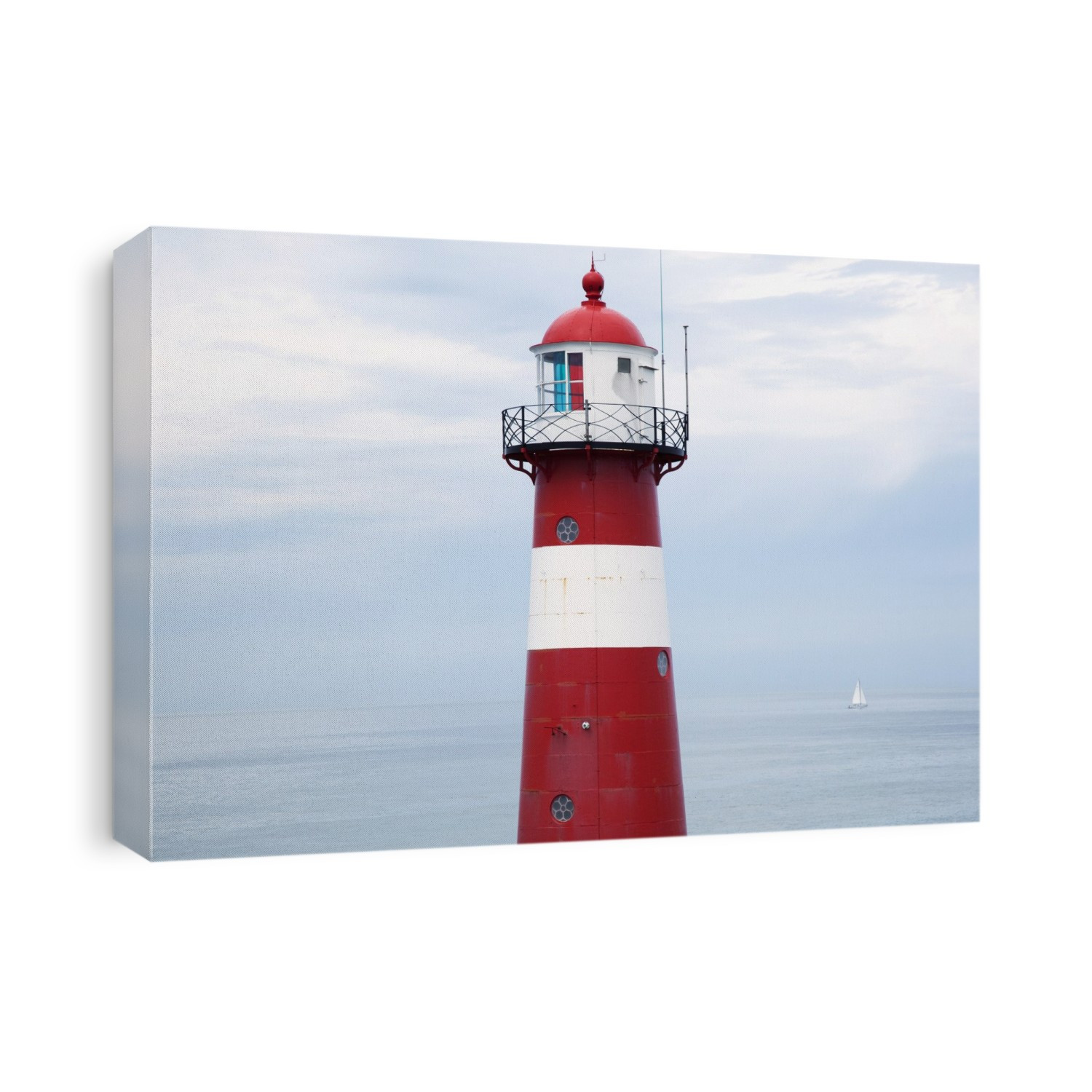 Red and white lighthouse along the coast with a sailboat in the distance near westkapelle; Zealand, netherlands