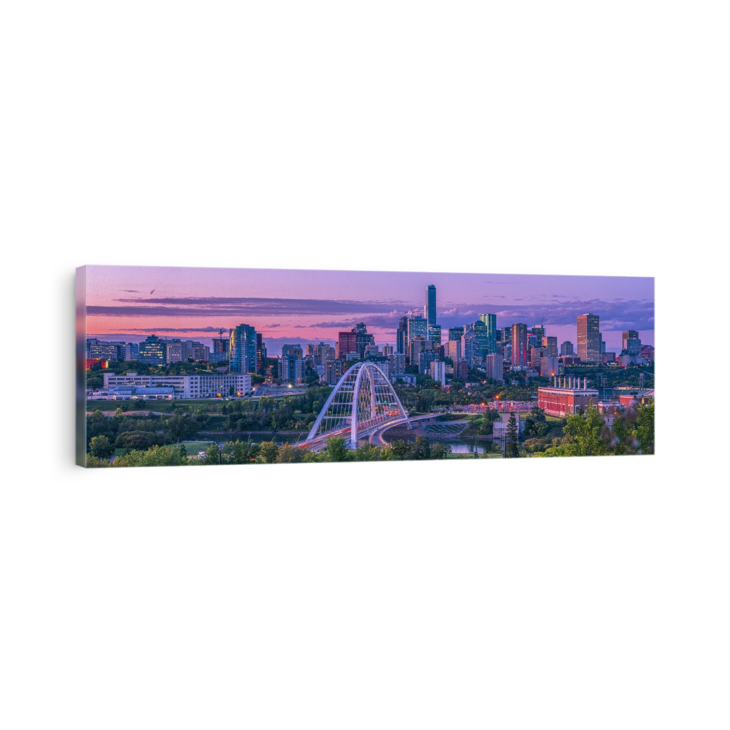 Skyline of Edmonton at dusk with a pink glow and the Walterdale Bridge crossing the North Saskatchewan River in the River Valley; Edmonton, Alberta, Canada