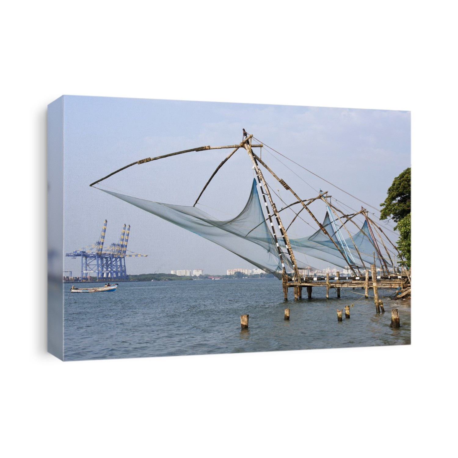 Coastal fishing nets in India. Chinese fishing nets on the end of jetties on a shoreline in Kochi (Cochin), Kerala, India. These fishing nets (also called cheena vala) are fixed and used as shore-operated lift nets. Using a counterweight system, they are lowered into the sea and then raised again after a short interval. The name derives from the theory that they were introduced by the Chinese, but it is now thought that they were introduced by the Portuguese from Macau. In the background at far left are container shipping cranes. Photographed in 2013.