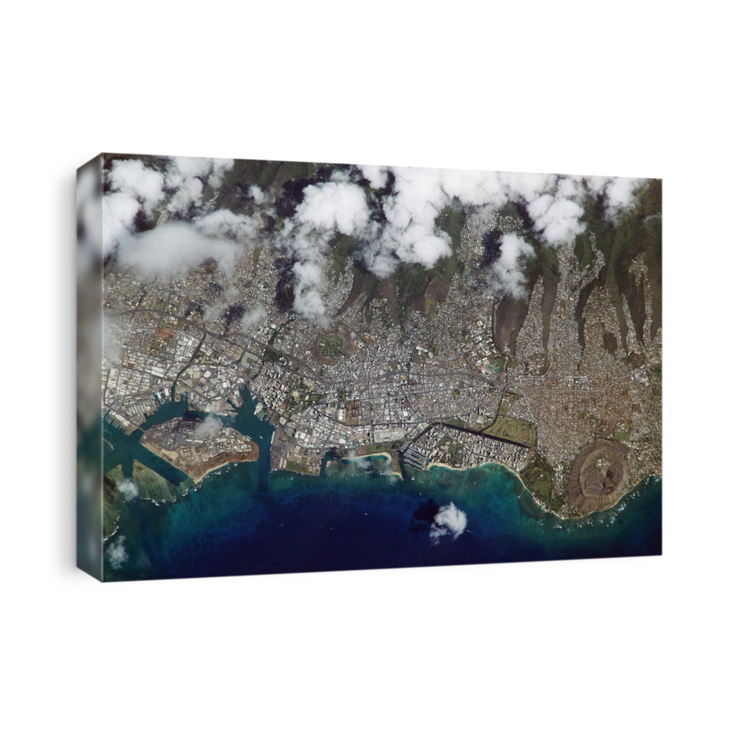Honolulu, Hawaii, as seen from the International Space Station (ISS). This city is located on the coast, with the waters of the Pacific Ocean across bottom, and the built-up areas extending onto the steep volcanic slopes across top (partially obscured by clouds). There are two large volcanic craters in the city. Punchbowl Crater (just left of centre) is the location of the National Memorial Cemetery of the Pacific. Diamond Head (1073 metres across) is at bottom right. Only parks and the steepest ridges remain undeveloped. Photographed by an Expedition 7 crew member on 8 October 2003.