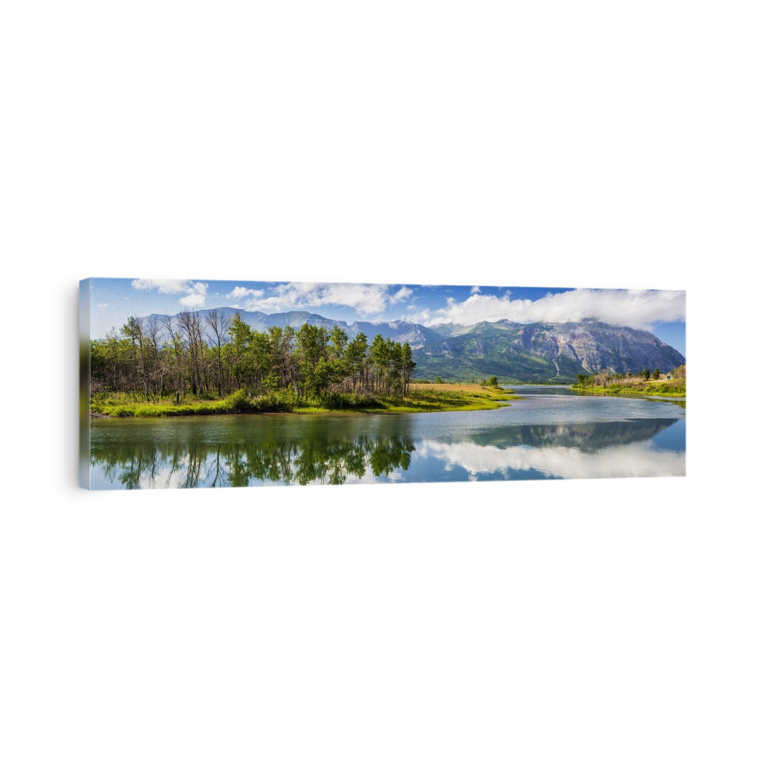 Panorama of mountain scape and tree island reflecting off a still lake with blue sky and clouds, Waterton Lakes National Park; Waterton, Alberta, Canada