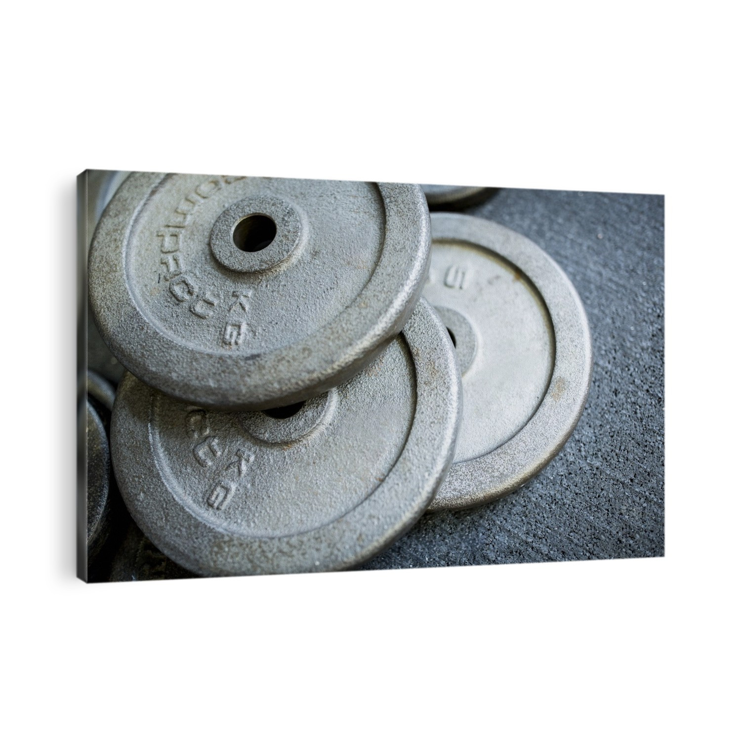 Close-up of heavy weight plates on the ground.