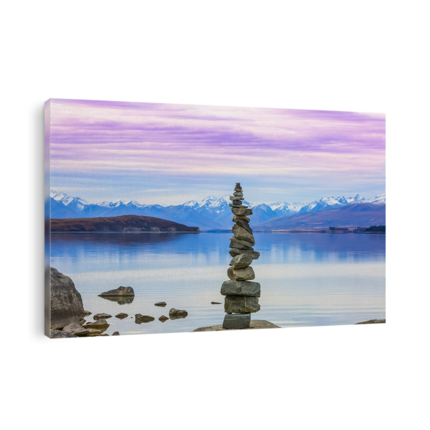 Beautiful views over the shoreline of New Zealand's Lake Tekapo at sunset. A stack of rocks sits lakeside; Lake Tekapo, Canterbury, New Zealand