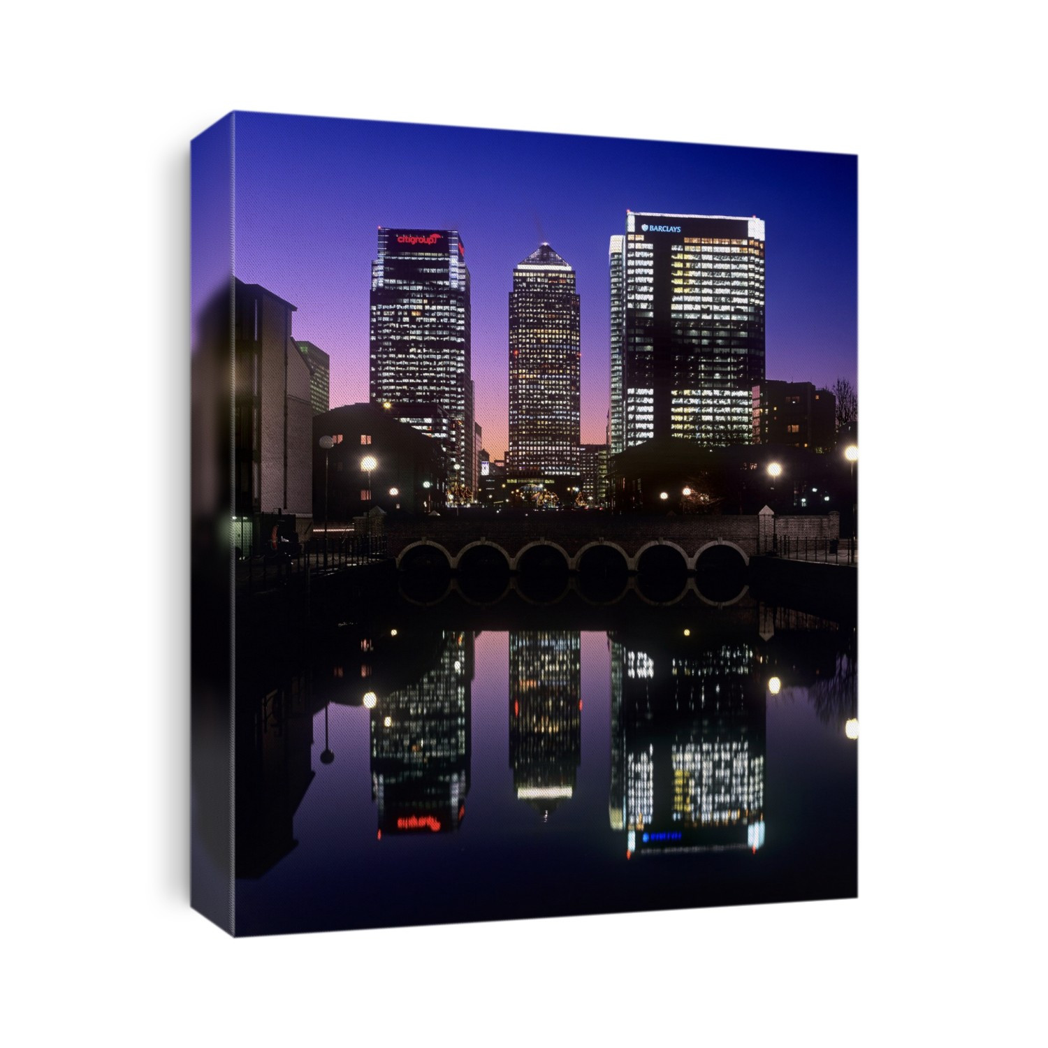 Canary Wharf at night. Office blocks reflected in the water of a former dock. Photographed in Canary Wharf, Docklands, London, UK.