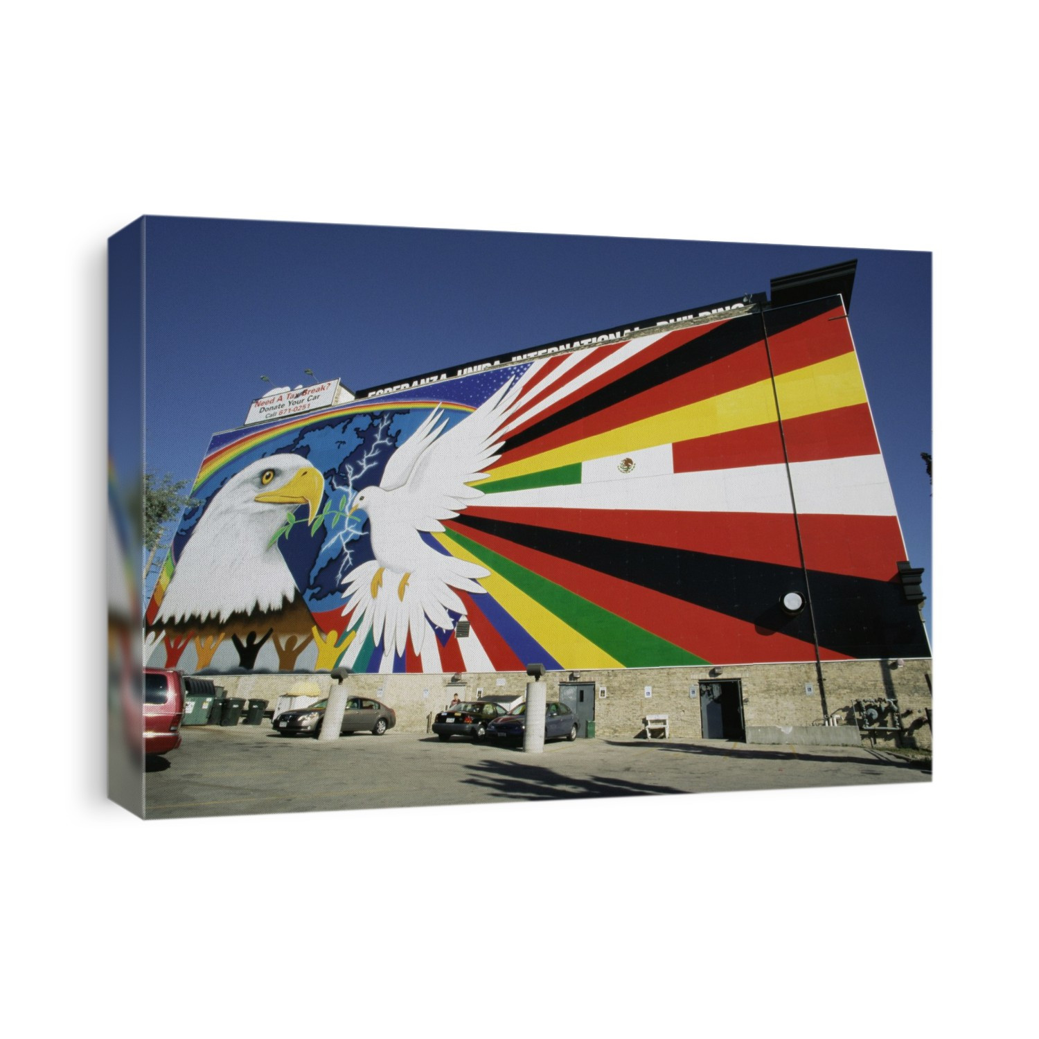 Wall painting. Mural painted on the side of a building. This is the Mural of Peace on the side of the Esperanza Unida International Building in Milwaukee, Wisconsin, USA. The mural shows a bald eagle (left) and a dove (white) holding an olive branch. Behind the birds is a map of the Americas. Above, right, and below the birds is a rainbow, different flags, and different colours of people. The bald eagle is the national symbol of the USA. A dove and an olive branch is a widely recognised symbol of peace. The mural, designed by Reynaldo Hernandez in 1991, and installed in 1993, is 18x46 metres. The mural was removed for restoration in 1999. It was reinstalled in 2001.