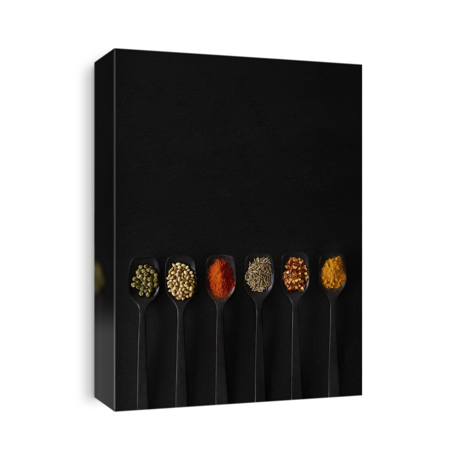 Dried spices on spoons, overhead view.