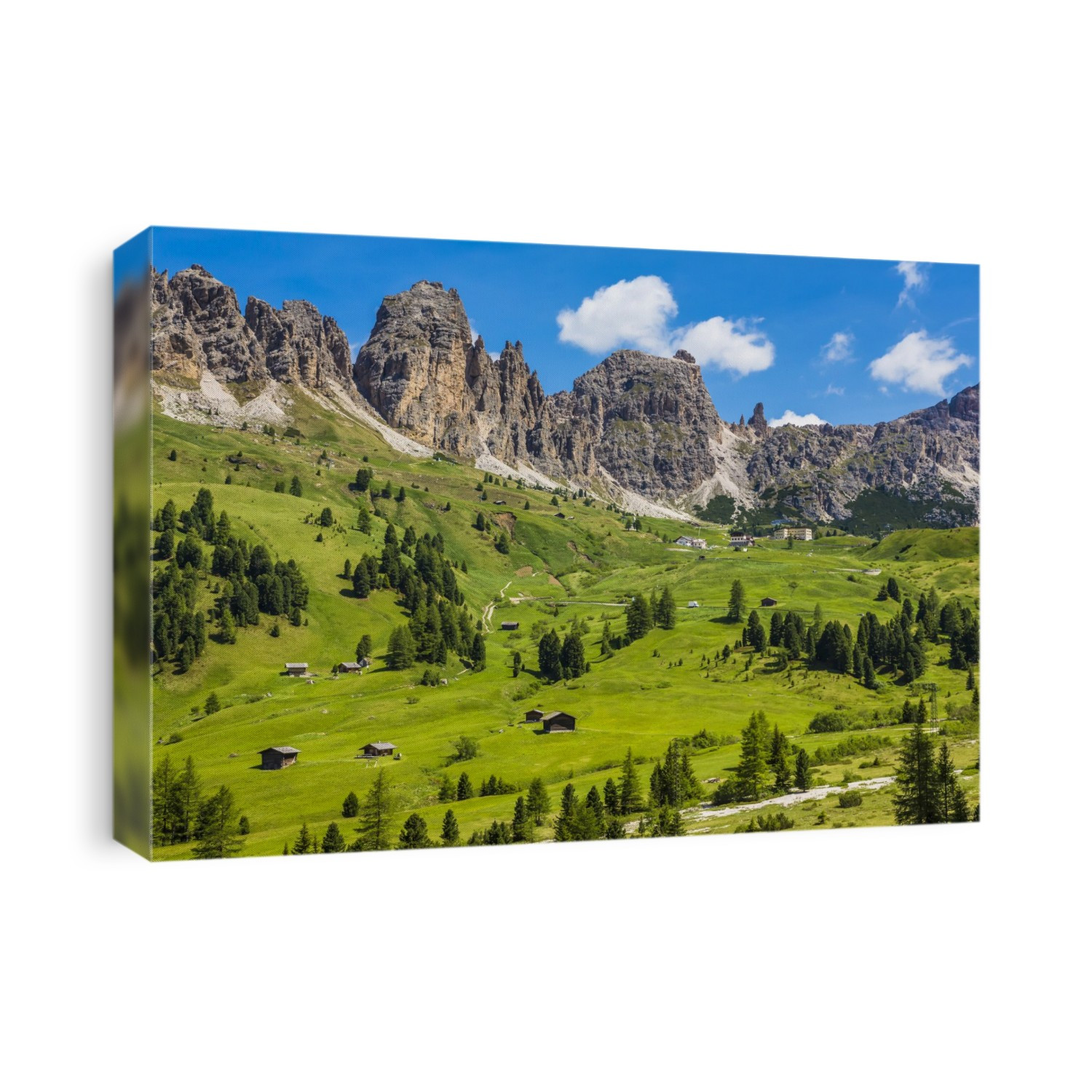Grassy mountain side with wooden mountain huts and the jagged mountain ridge at the Gardena Pass in the Dolomites in South Tyrol, Italy