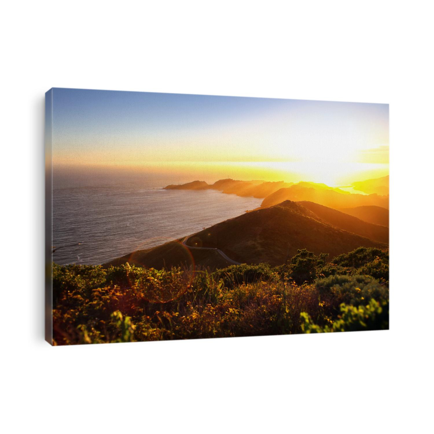 Dramatic coastal sunset with island peninsula and golden light ocean