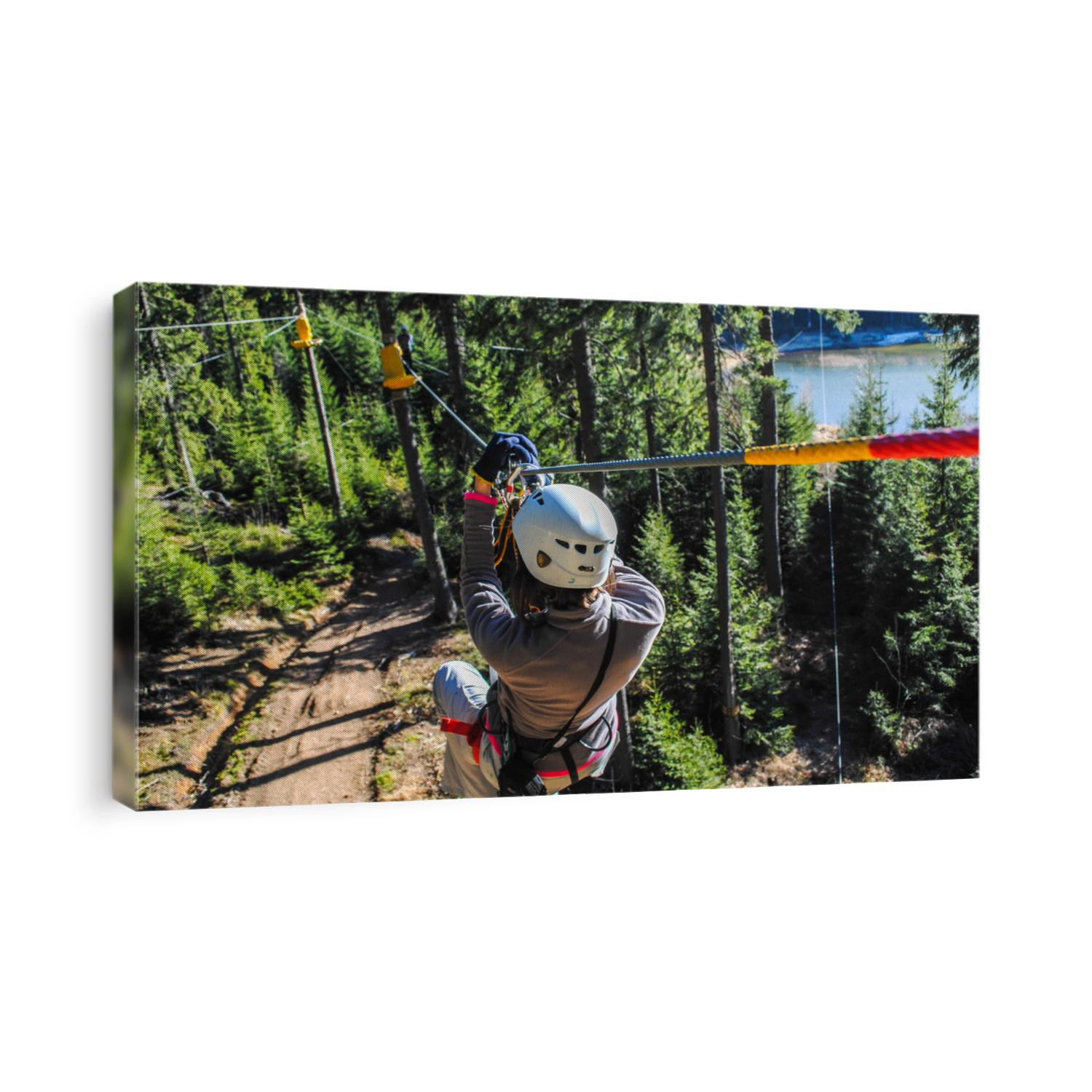 Woman sliding on a zip line in an adventure park