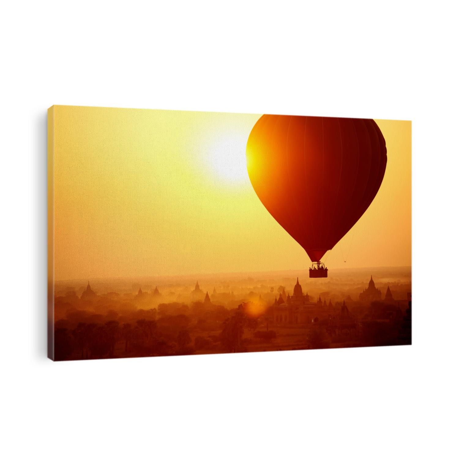 Silhouette of hot air balloon over Bagan in Myanmar, tourists watching sunrise over ancient city