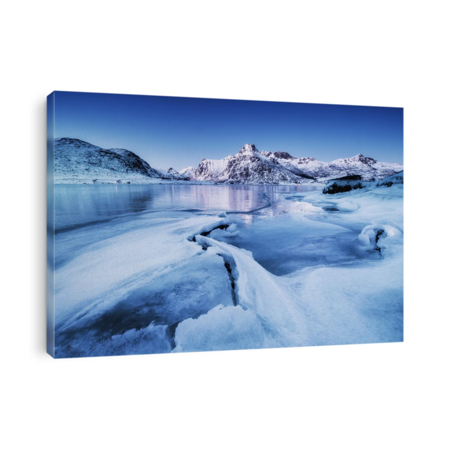 Mountain ridge and ice on the frozen lake surface. Natural landscape on the Lofoten islands, Norway. Water and mountains during sunset.