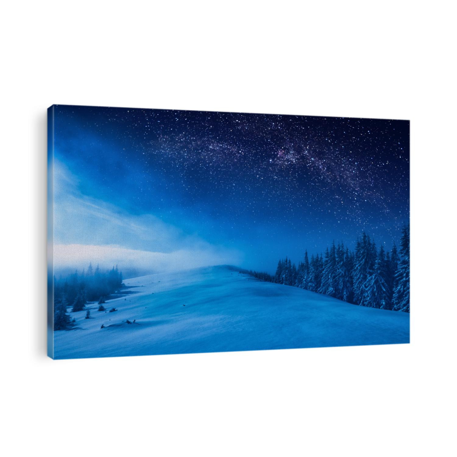 Forest on a mountain ridge covered with snow. Milky way in a starry sky. Christmas winter night.