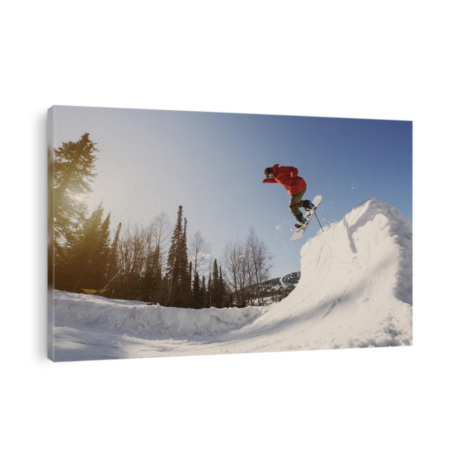 Snowboarder male jumping on quarter pipe snowboard in winter sunny day. Freestyle snowboard training