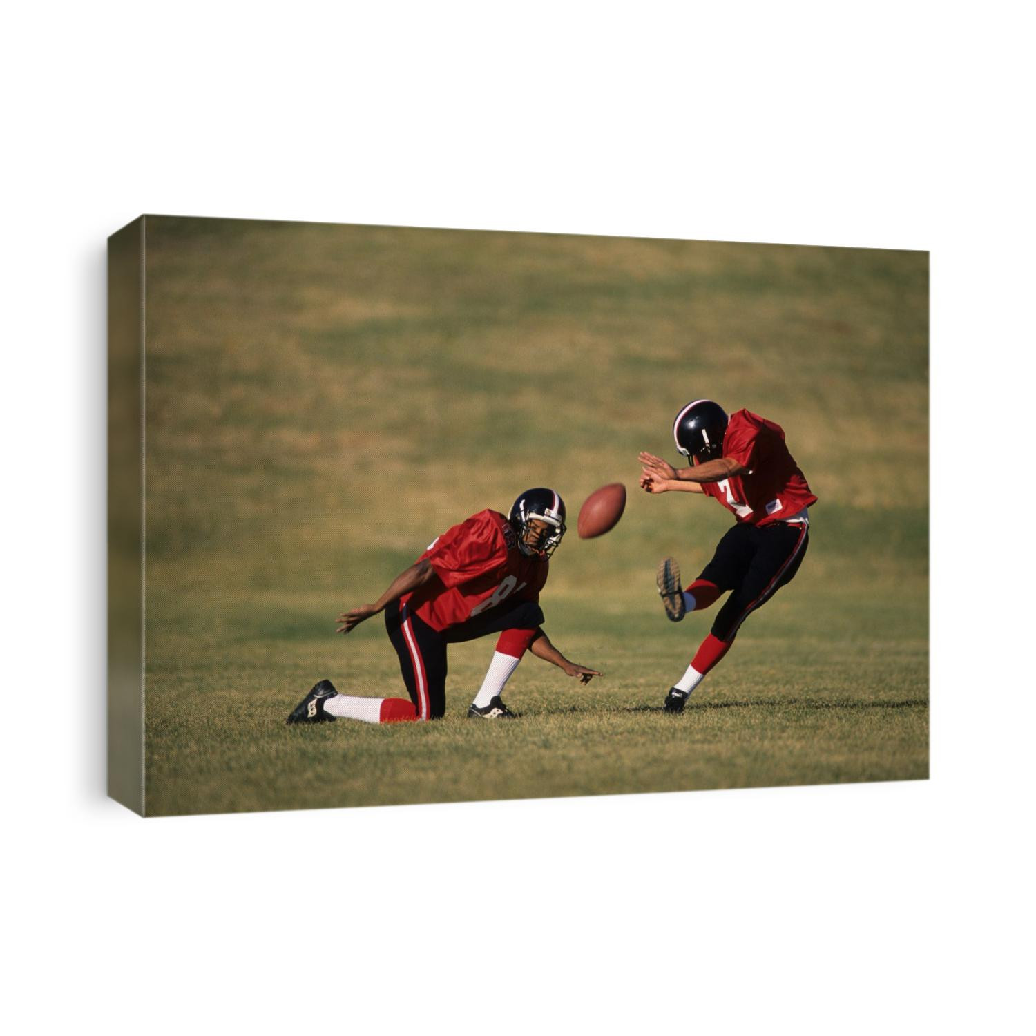 Football place kicker and holder in action