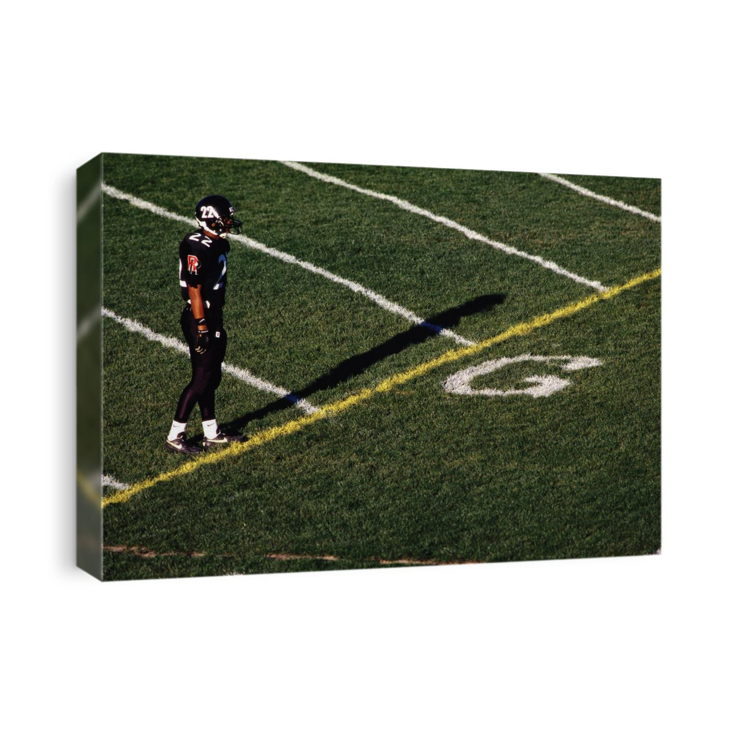 Football player standing at the goal line.