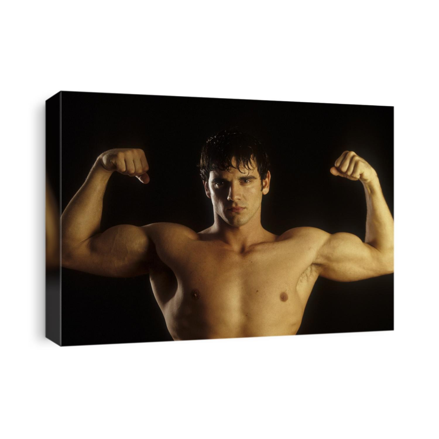 Young adult male posing with arms flexed.