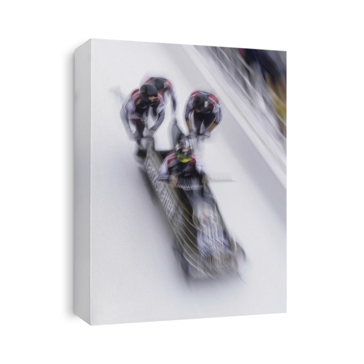 Blurred action of the start of 4 man bobsled team.