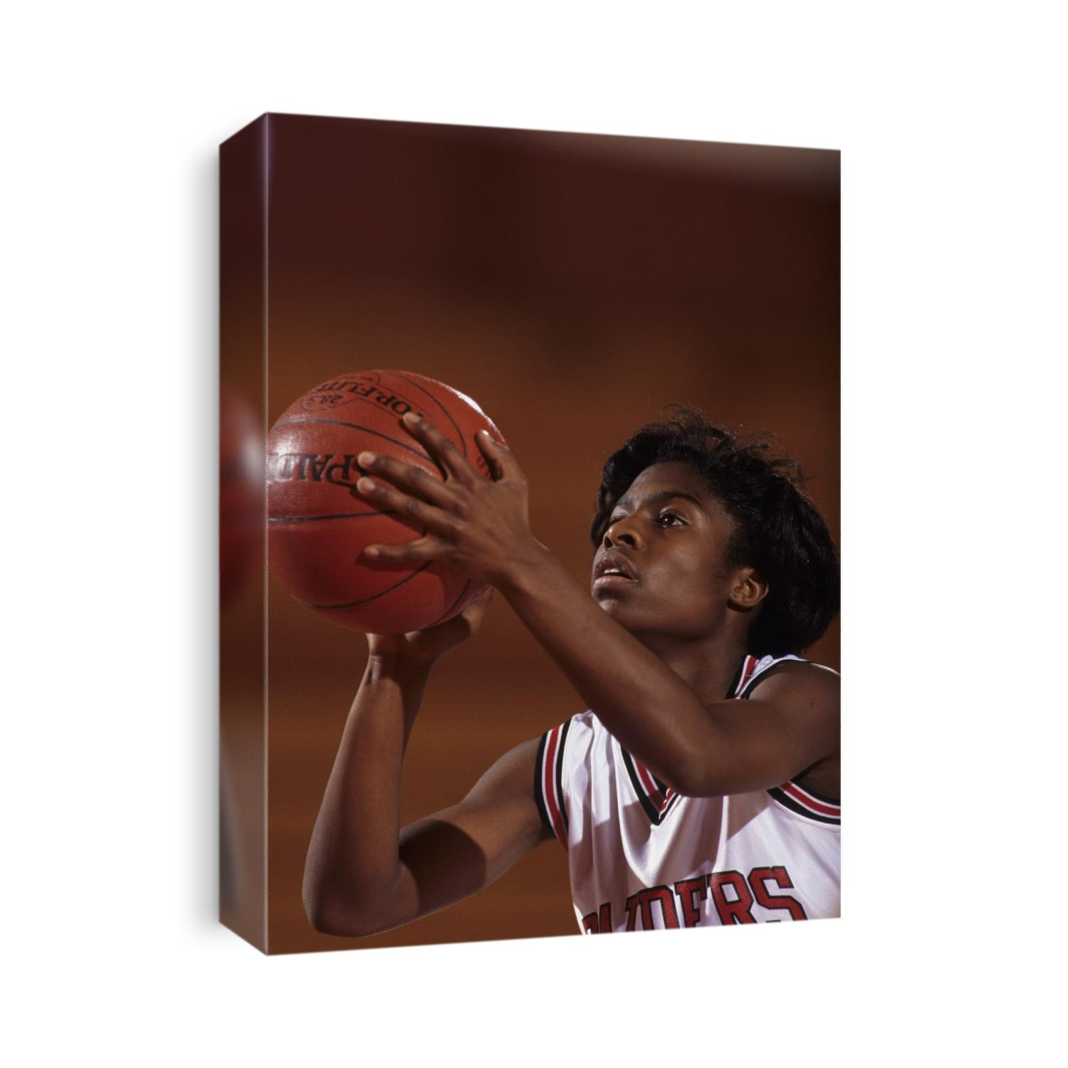 Female High Schooll basketball player in action shooting a free throw during a game.