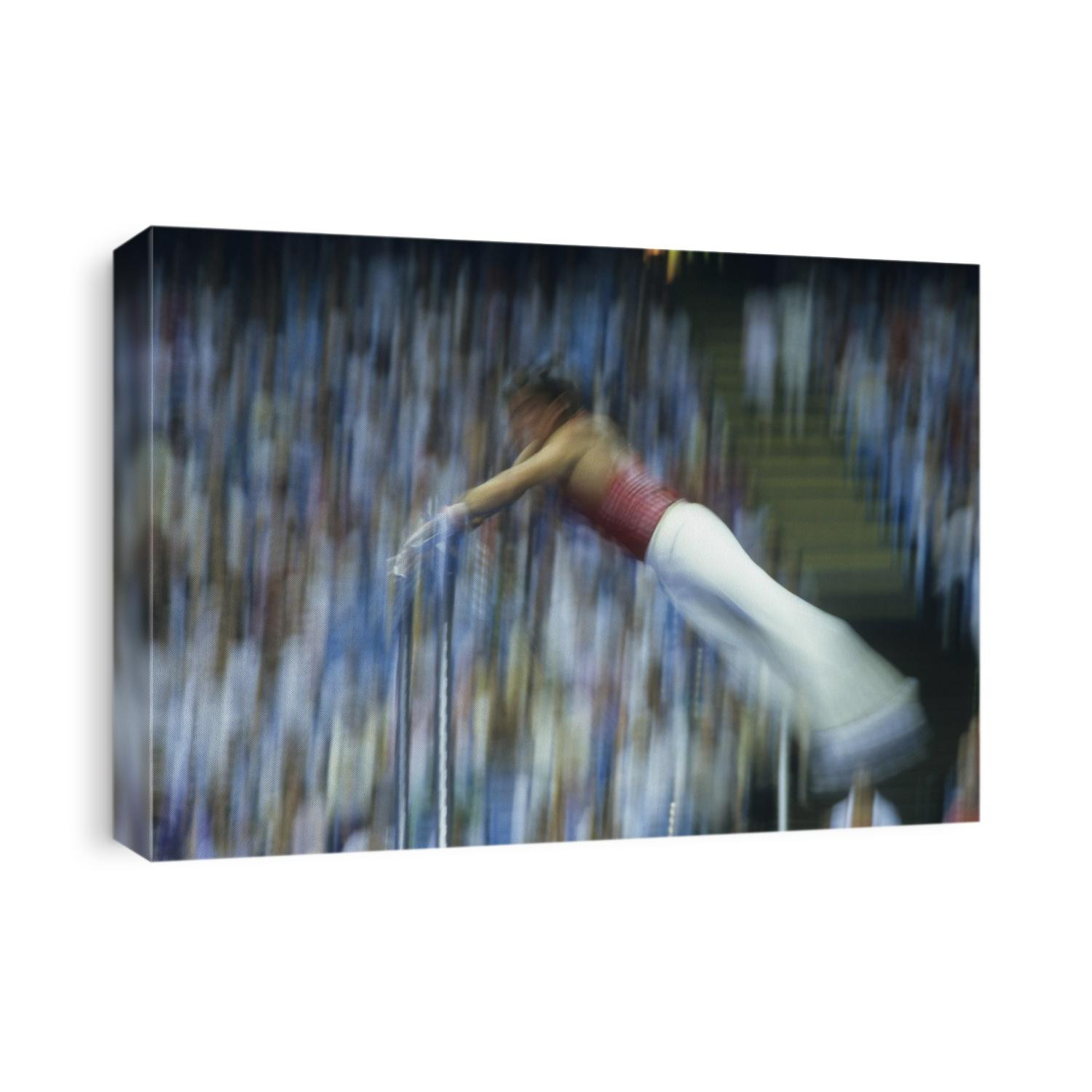 Blurred action of male gymnast on the horizontal bar.