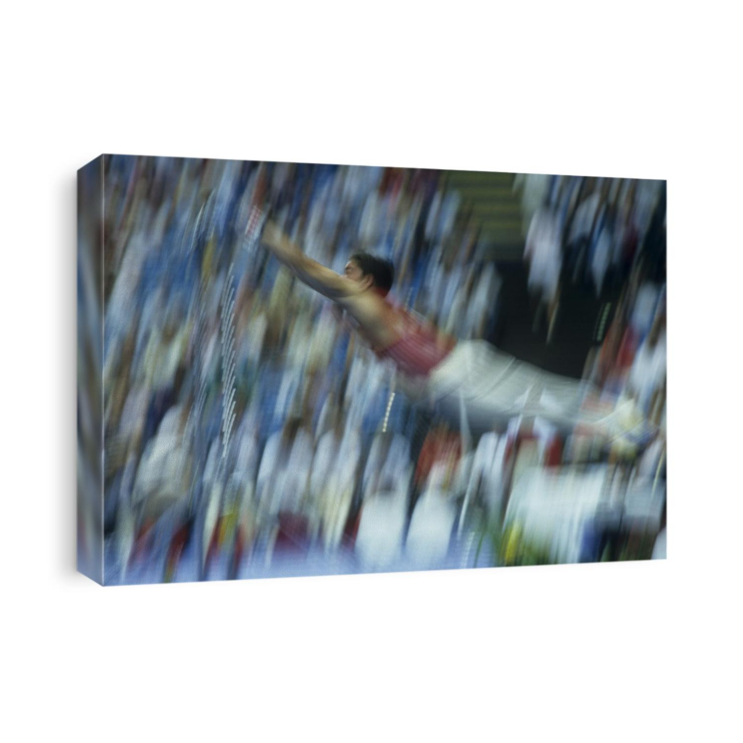 Blurred action of male gymnast on the horizontal bar.