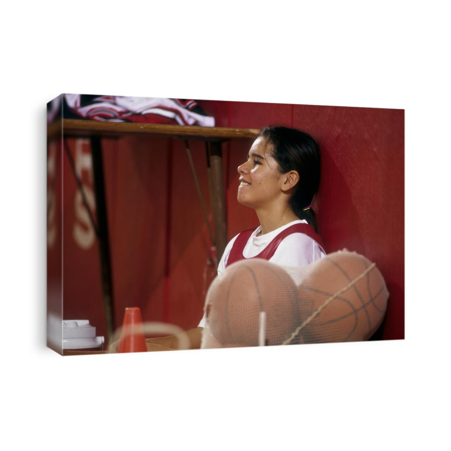 High Scholl girls basketball player resting during practice session.