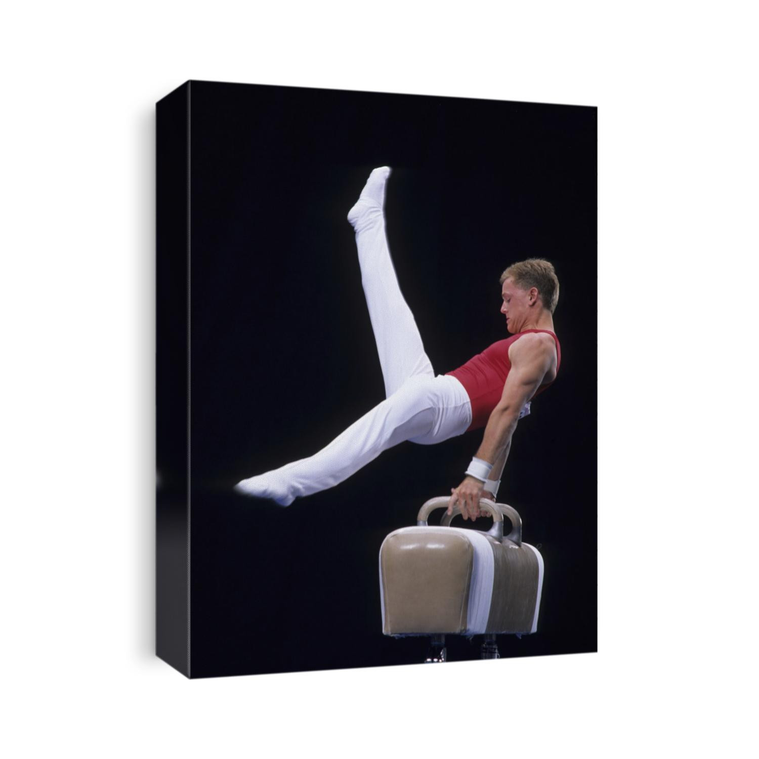 Male gymnast performing on the pomell horse.