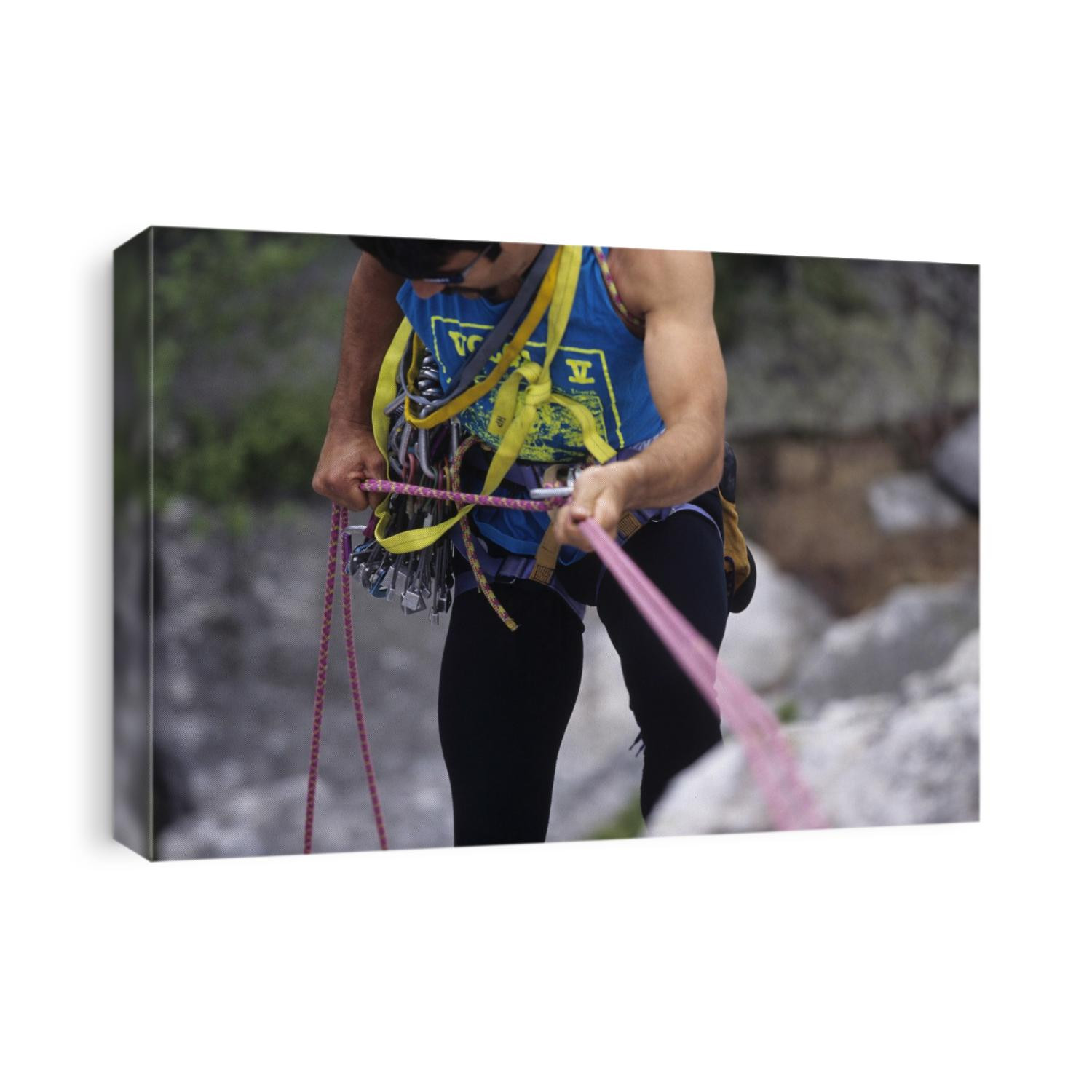 Detail of male rock climbing working with his ropes.