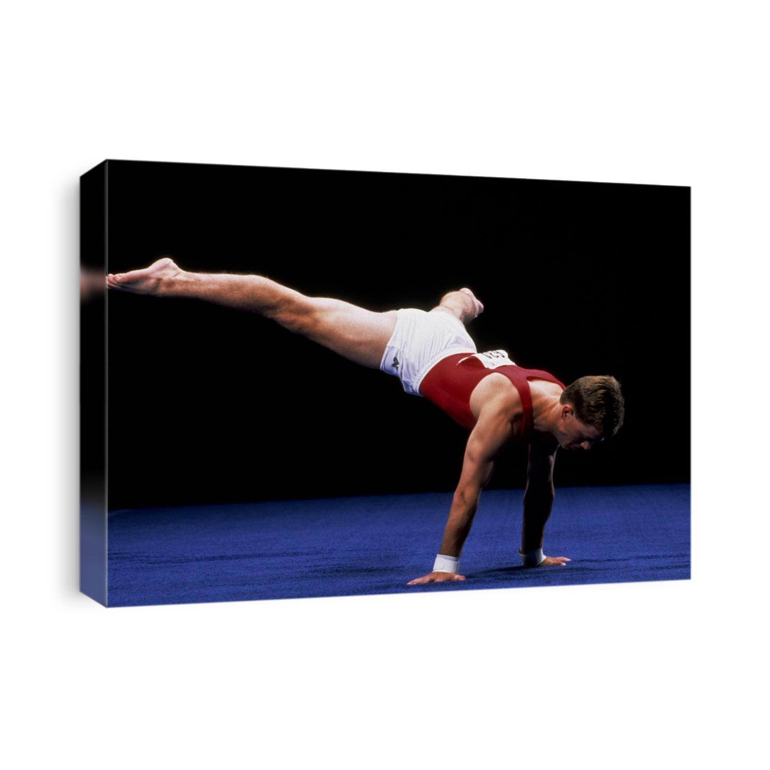 Male gymnast performing on the floor exercise.