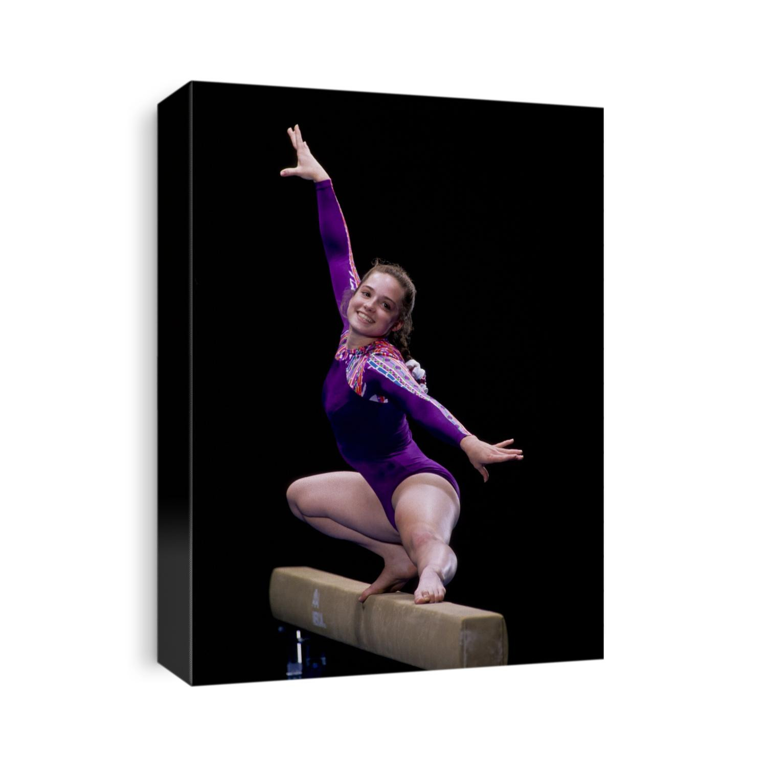 Female gymnast performing on the balance beam.