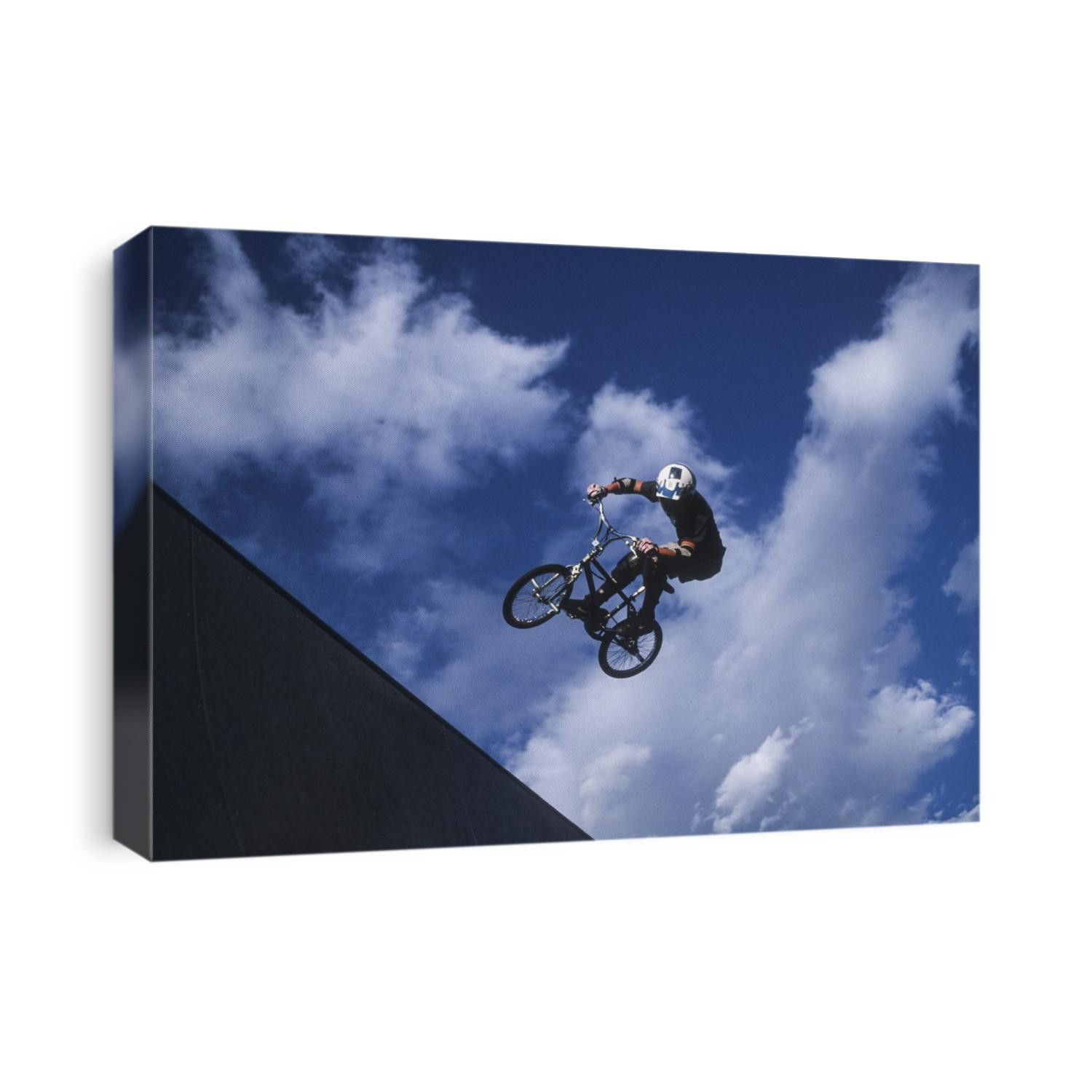 Teenage boy flys over the vert on a BMX bike.