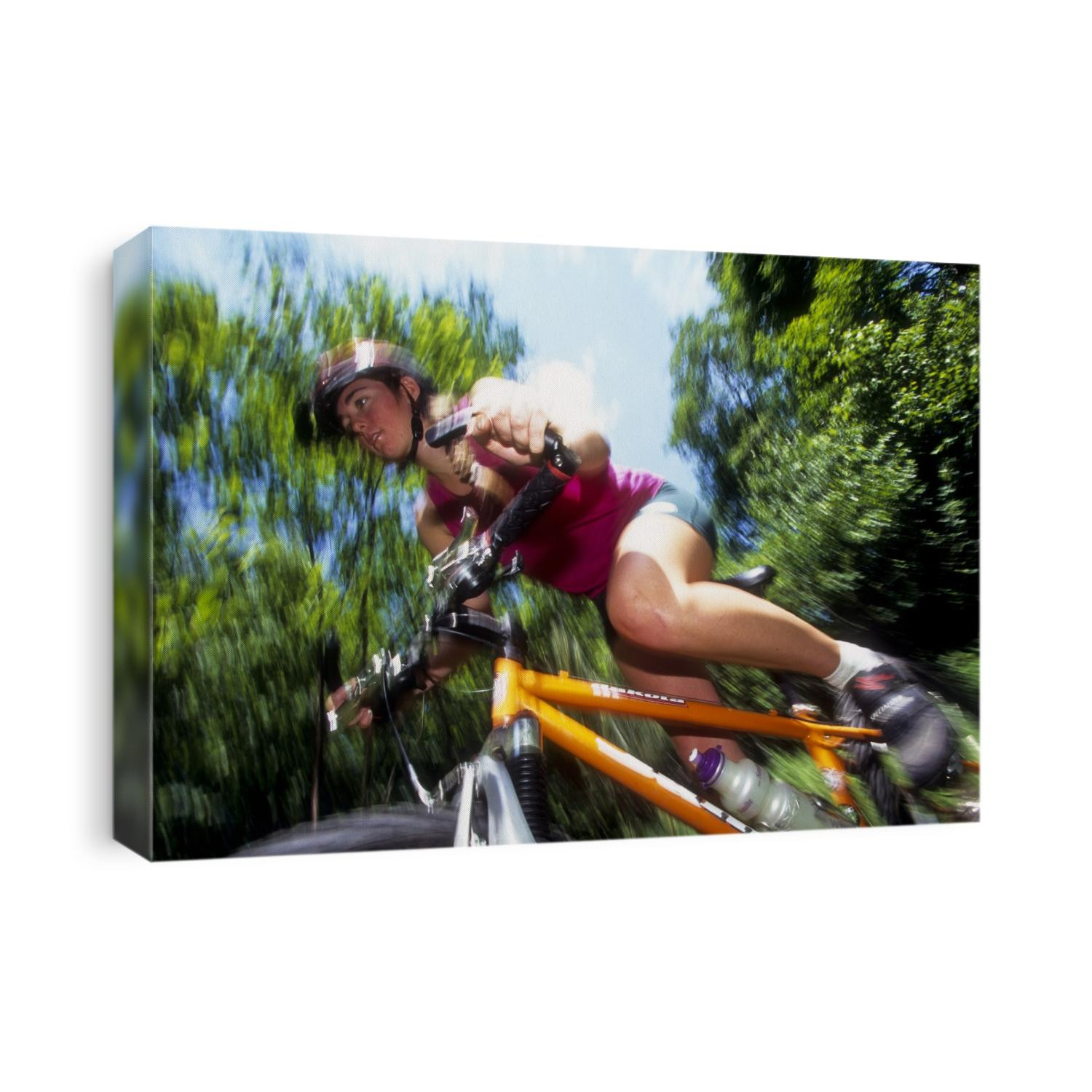 Young female recreational mountain biker riding in the forest.