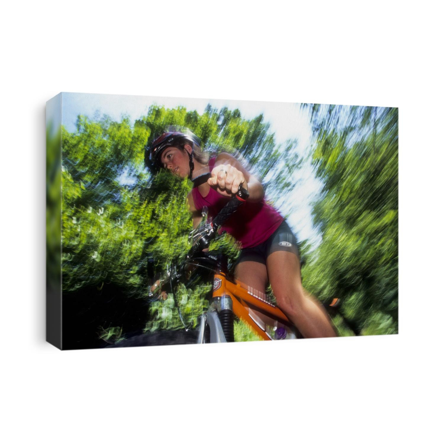 Young female recreational mountain biker riding in the forest.