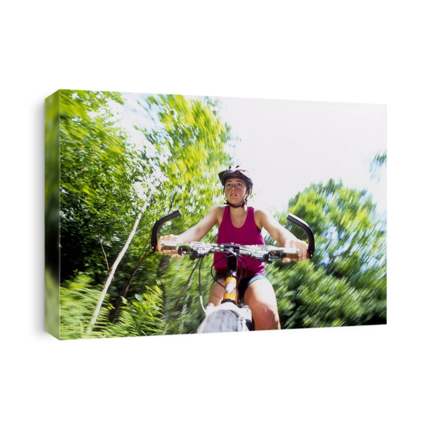 Young female recreational mountain biker riding in the forest.