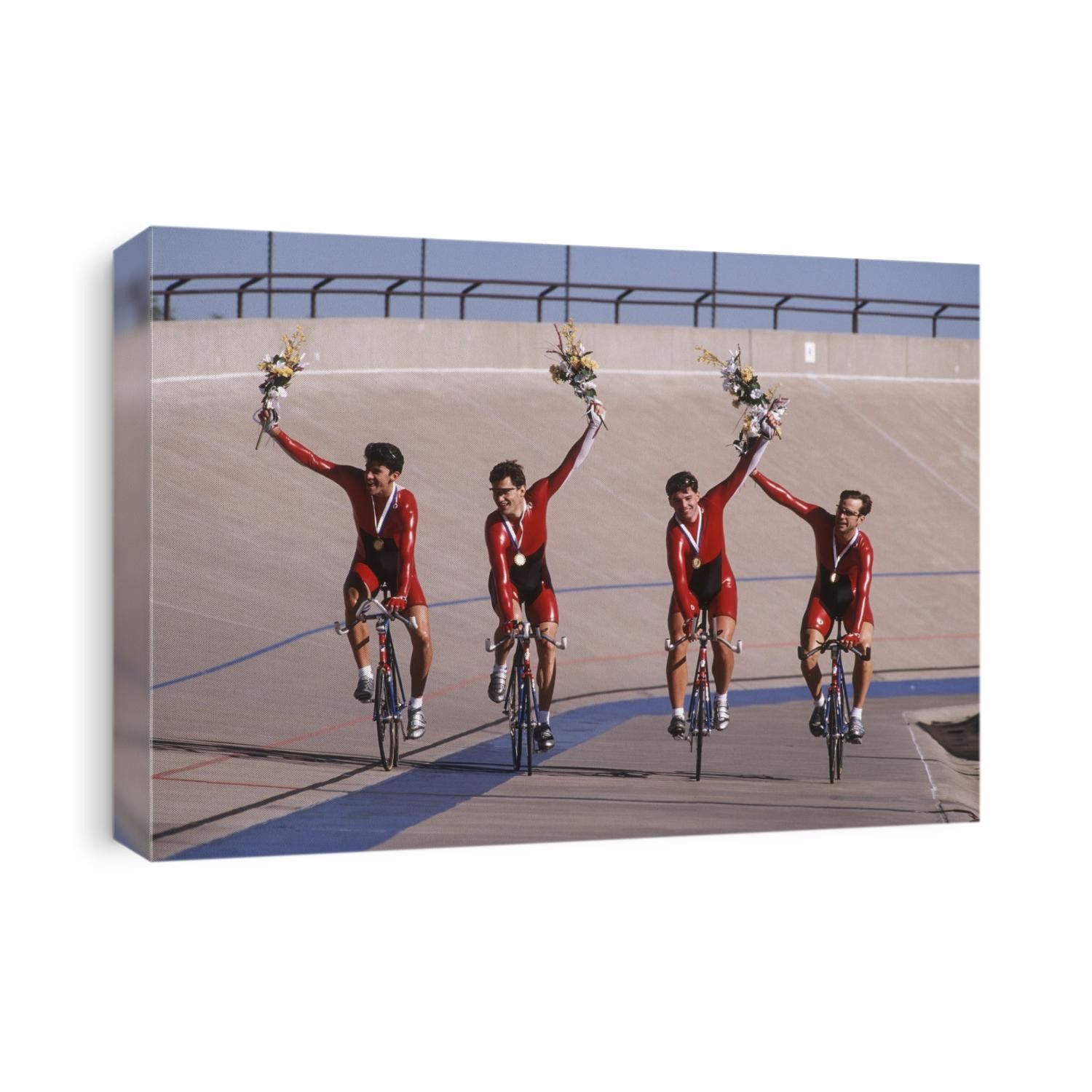 Victorious male cycling team on the velodrome.