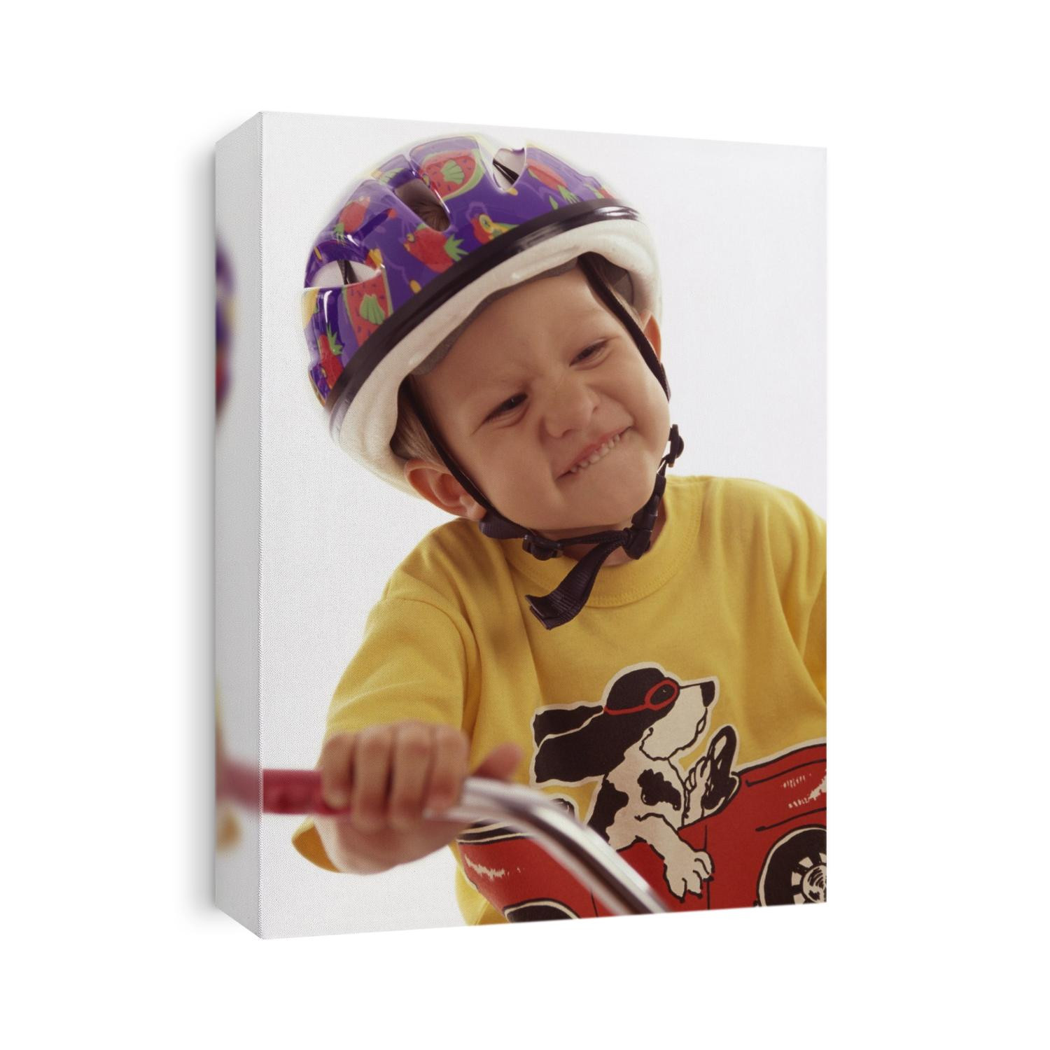 4 year old boy posing on his tricycle.