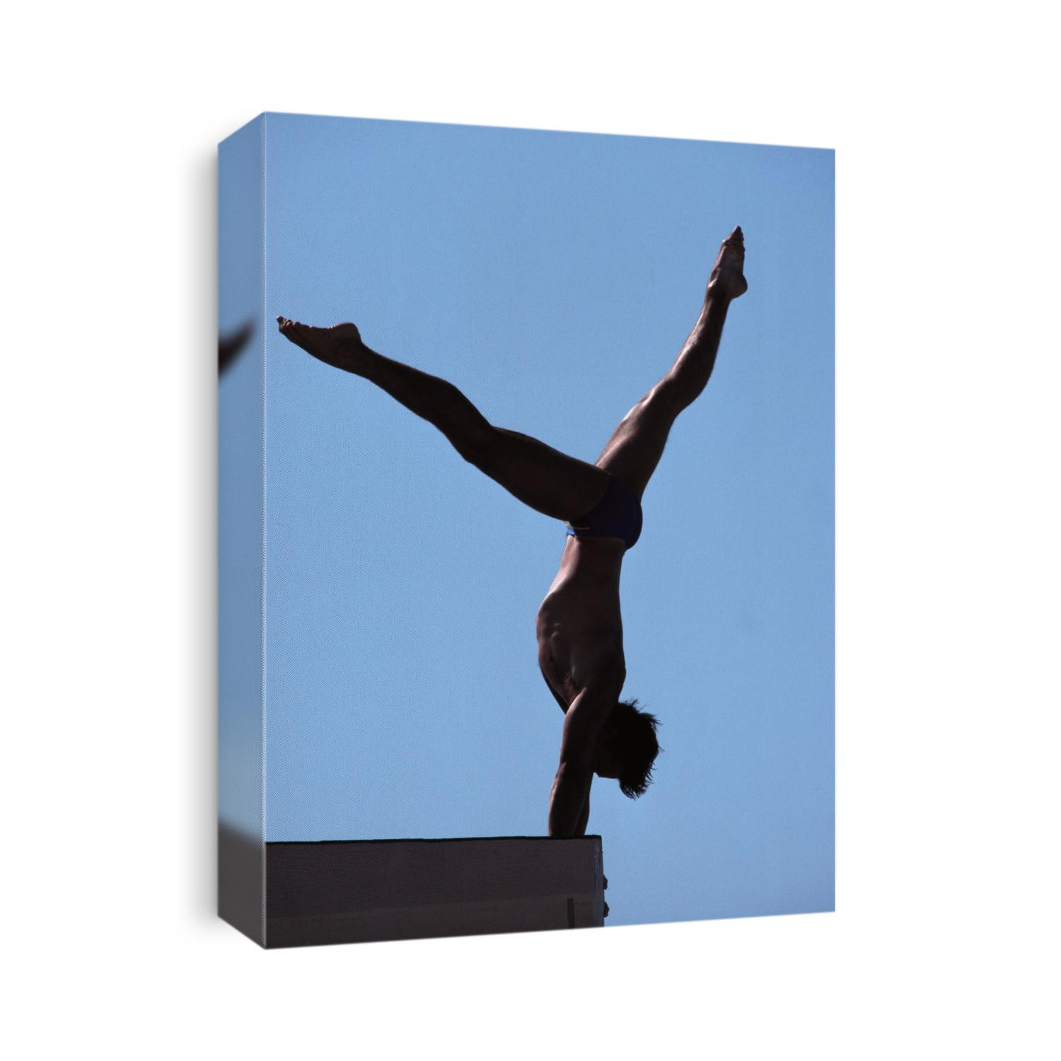 Silhouette of male diver about to dive off the 10m platform.