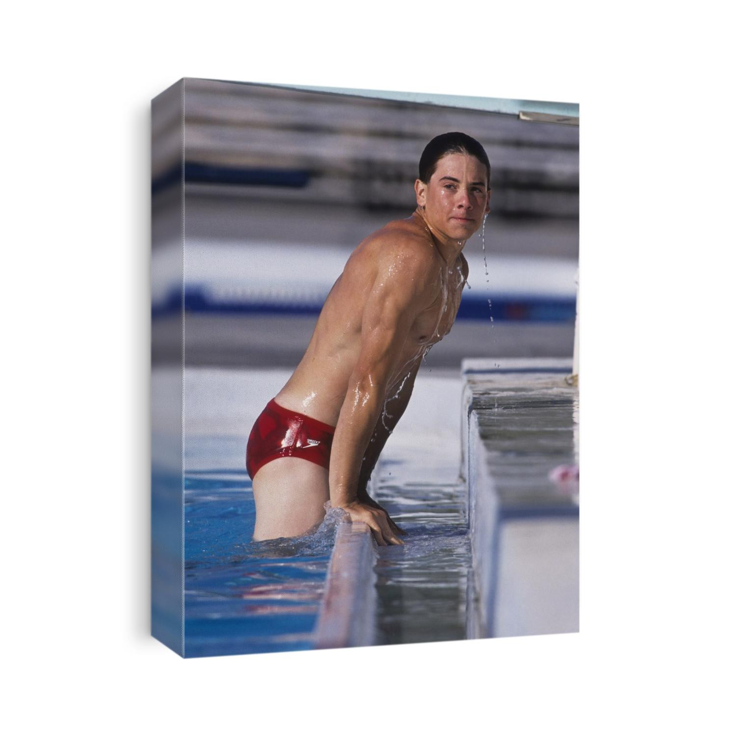 Male swimmer climbing out of the pool.