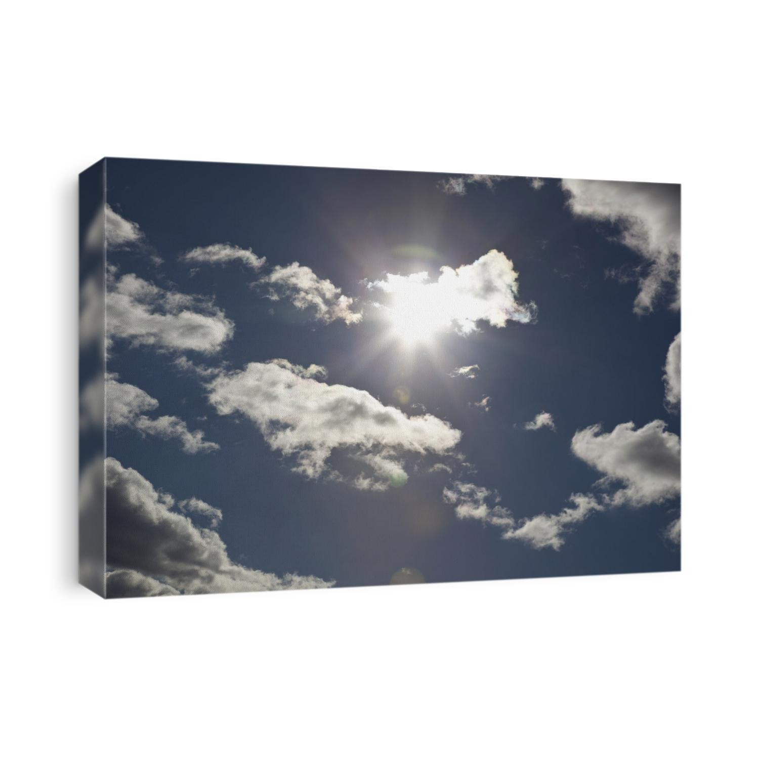 Sun in the sky behind cloud cover.