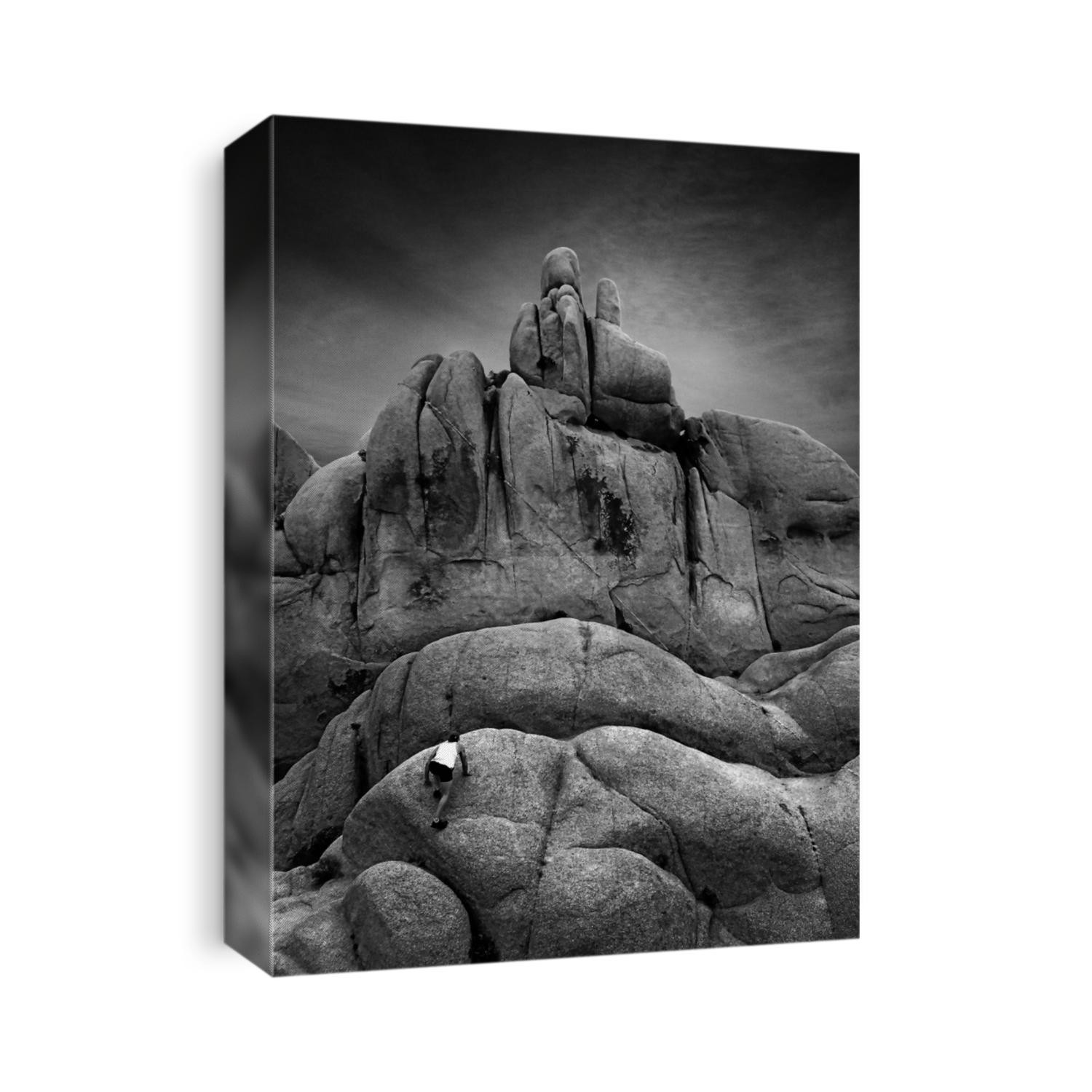 Man climbing giant boulders in Joshua Tree National Park in California