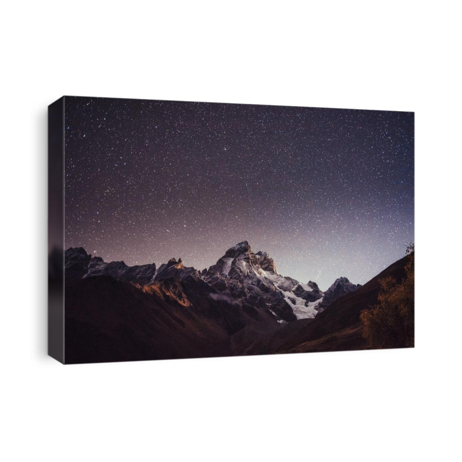 Fantastic starry sky. Autumn landscape and snow-capped peaks. Main Caucasian Ridge. Mountain View from Mount Ushba Meyer, Georgia. Europe.