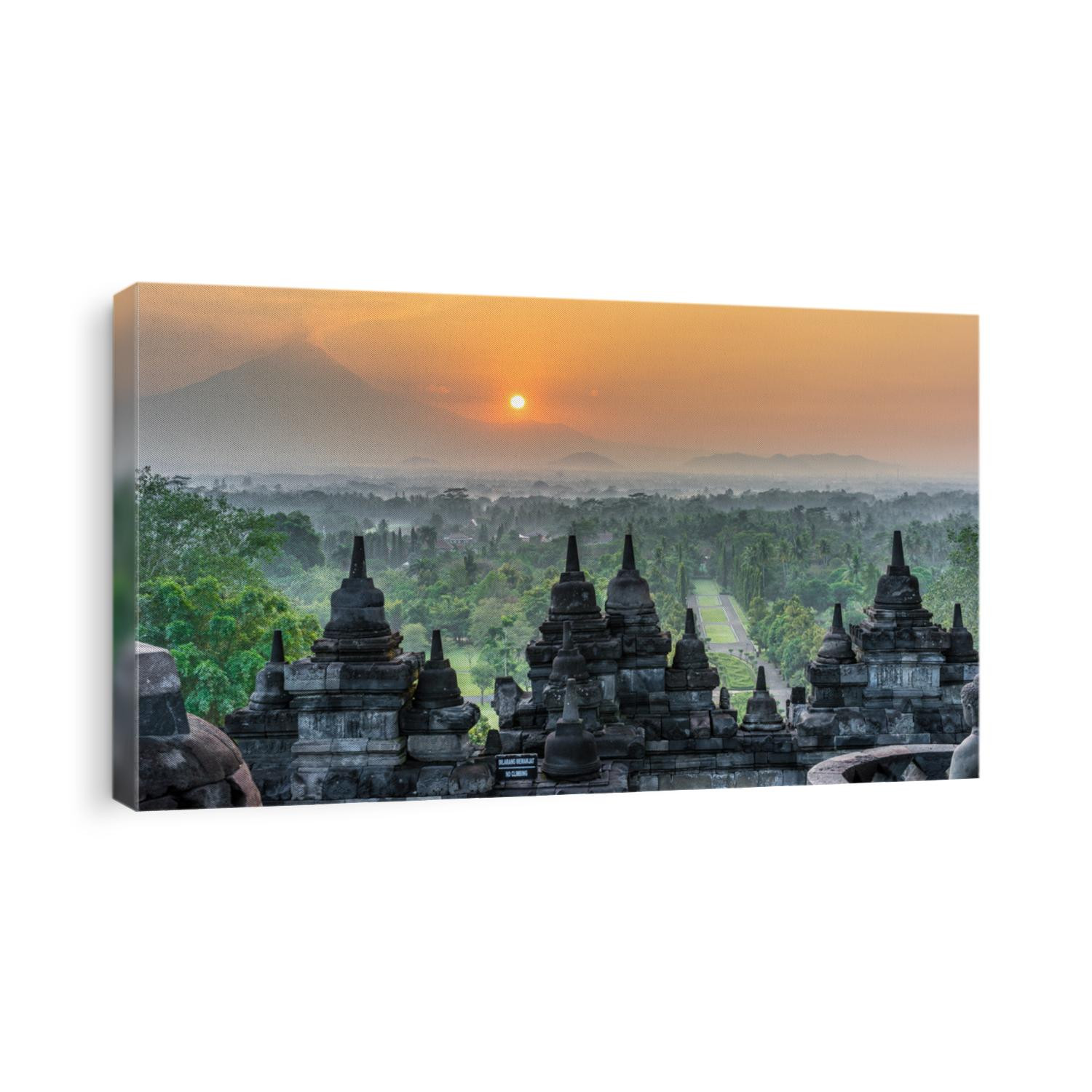 Sunrise panorama of Mount Merapi, Borobudur valey covered with mist and 9th century Stone Stupa at Borobudur Buddhist temple (UNESCO World Heritage Site). Magelang, East Java, Indonesia