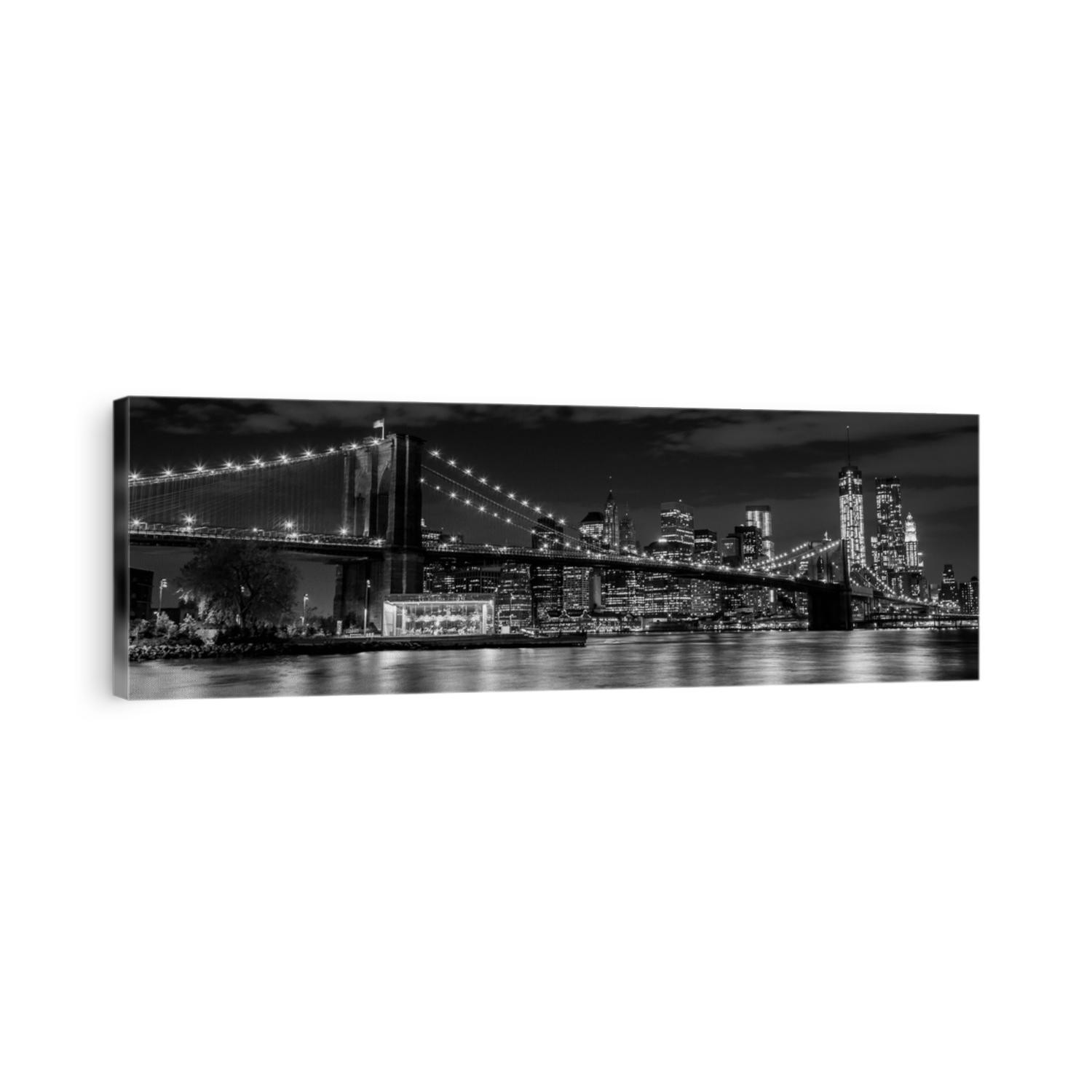 Brooklyn Bridge with Manhattan skyline in the background at night in black and white