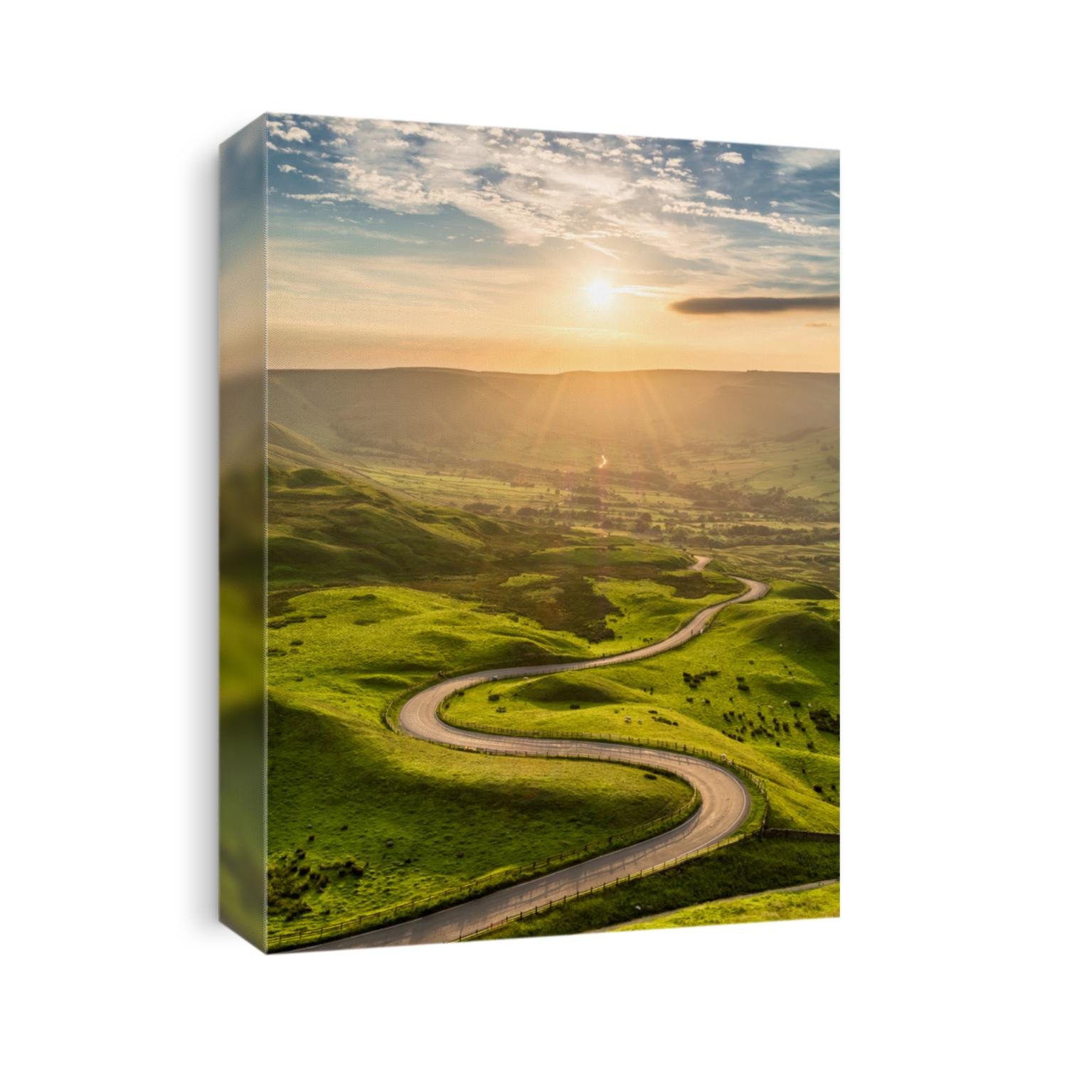 A long and winding road passing through green hills at sunset.
