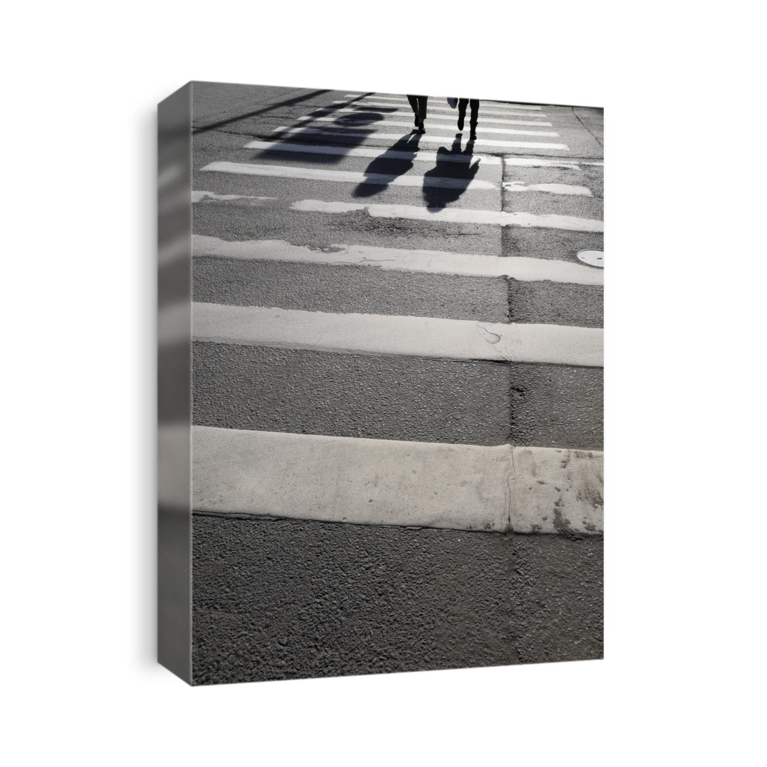 Asphalt texture background with legs and shadows citizens crossing road on pedestrian zebra