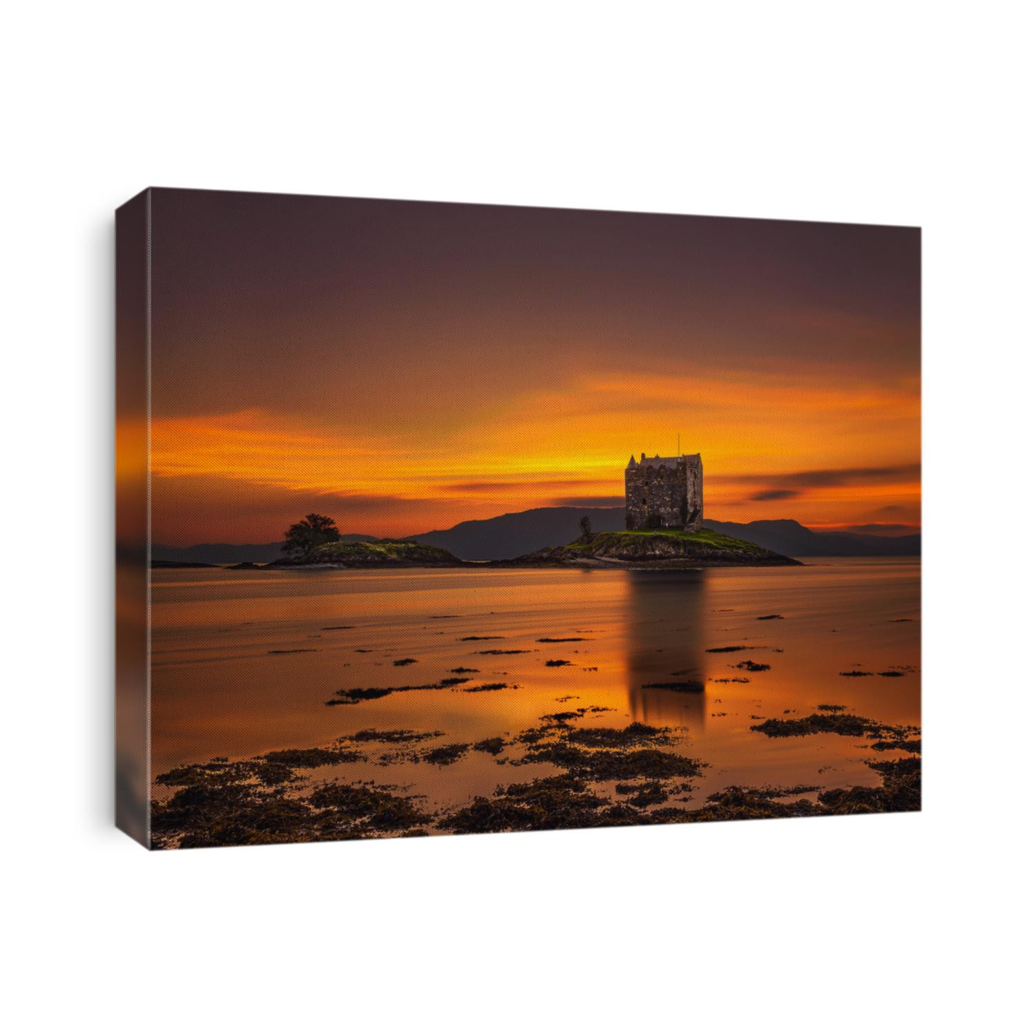 Dramatic sunset over Castle Stalker with reflection in Loch Appin located in Scotland, United Kingdom. Long exposure and hdr processed.