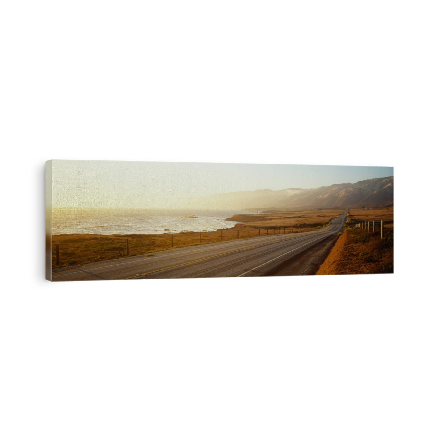 This is Route 1, also known as the Pacific Coast Highway. The road is situated next to the ocean with the mountains in the distance.