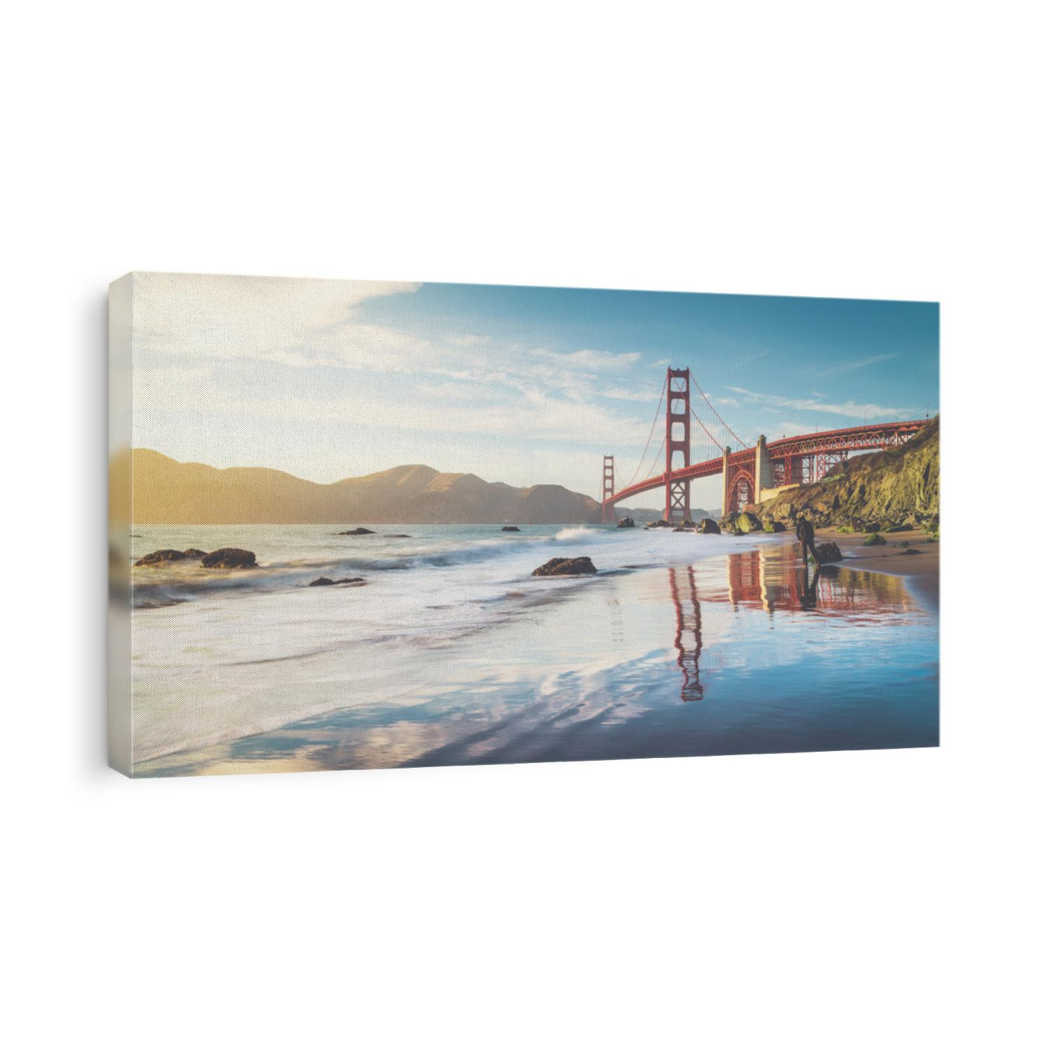 Classic panoramic view of famous Golden Gate Bridge seen from scenic Baker Beach in beautiful golden evening light on a sunny day with blue sky and clouds in summer, San Francisco, California, USA